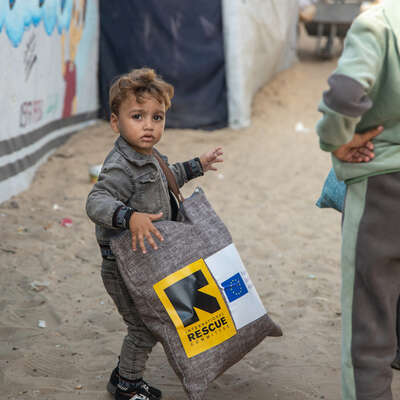 Ett barn står vid utdelningsplatsen för vinterkläder som RESCUE tillhandahåller i Khan Younis, södra Gaza.