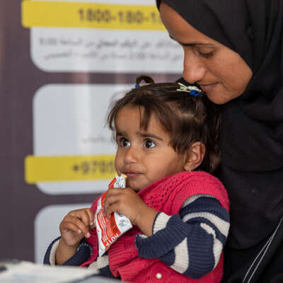Child with packet of RUTF peanut paste used to treat malnutrition