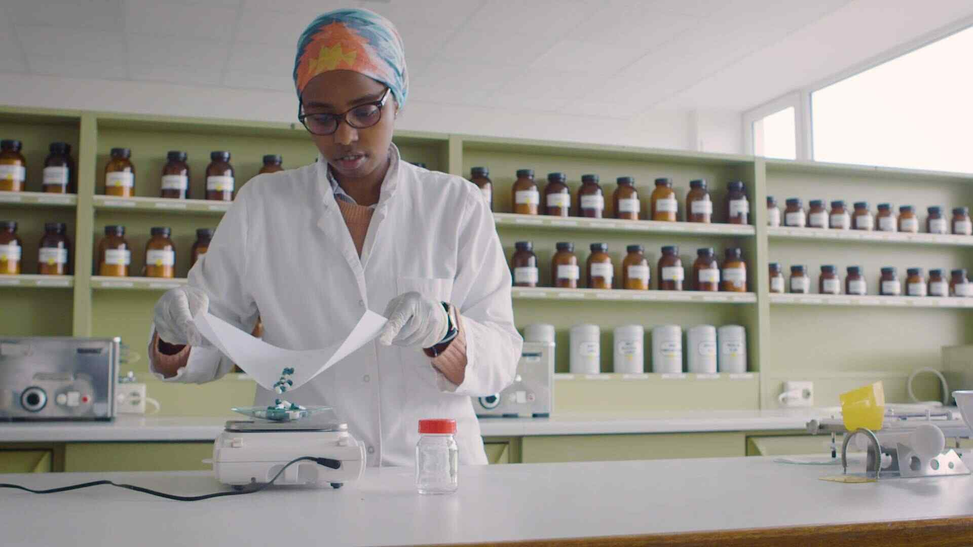 Eine junge Frau füllt Tabletten in einem Labor ab