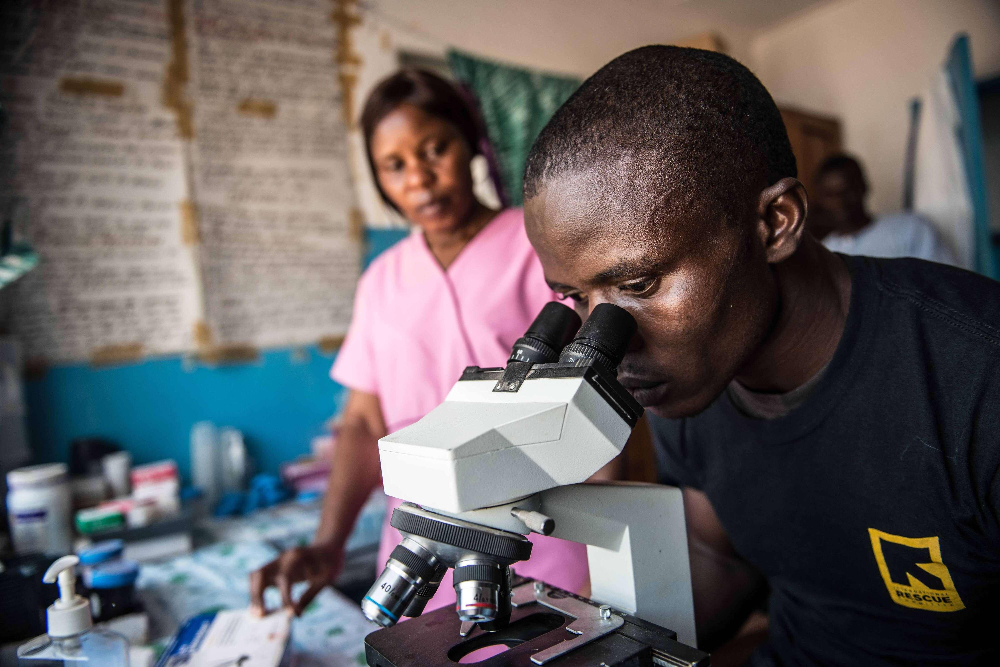 A man looking through an Microscope