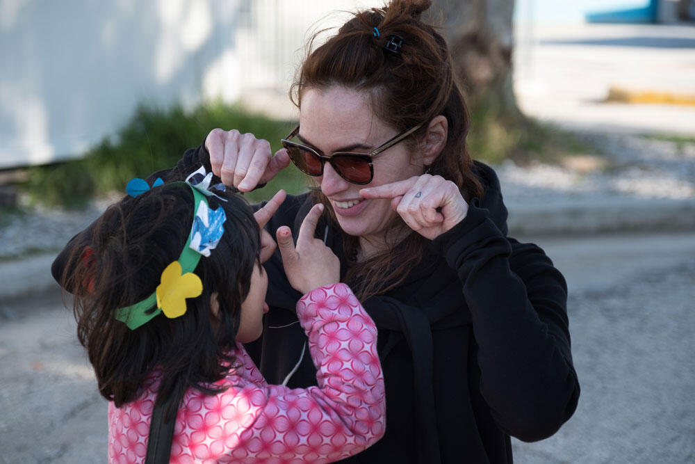 Eine Frau mit Sonnenbrille albert mit einem kleinen Mädchen herum.