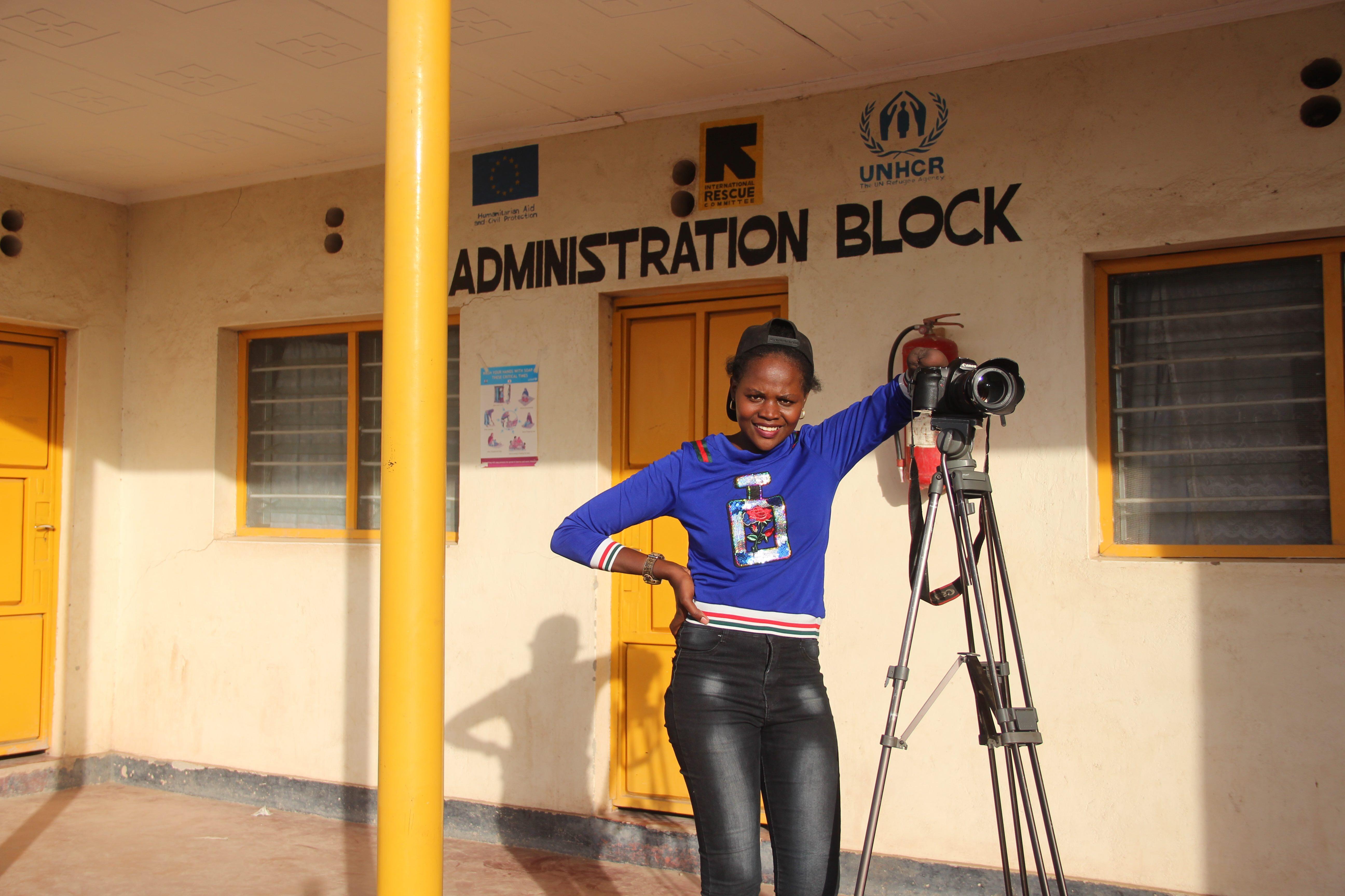 patience posing with her camera in front of an office