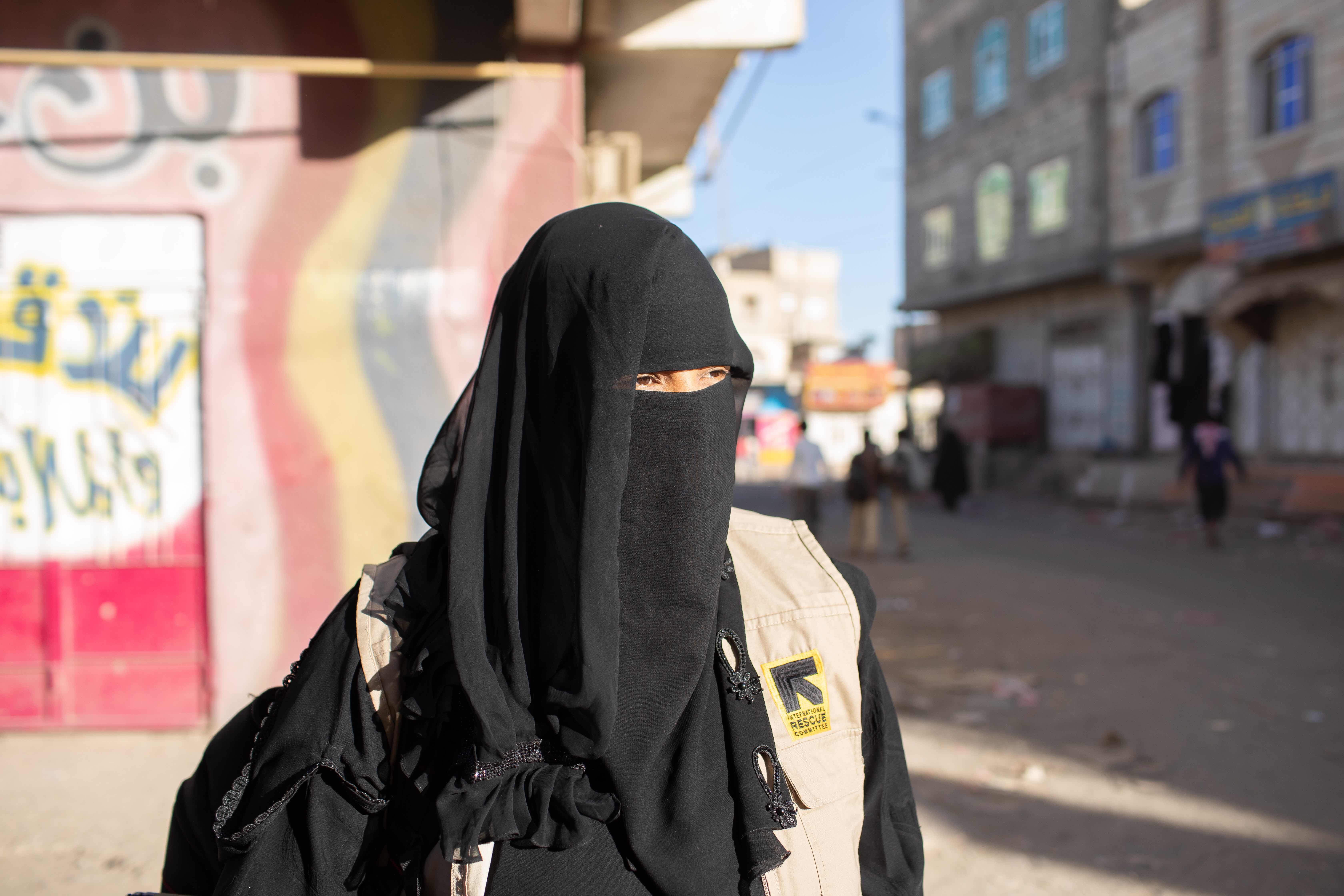 Tahani is fully veiled and is walking in a street