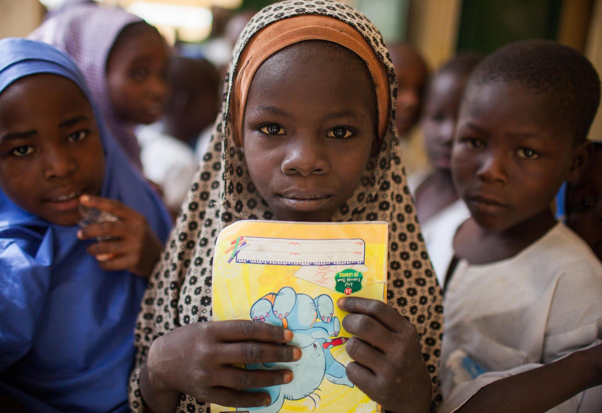 A little girl showing some book the the camera