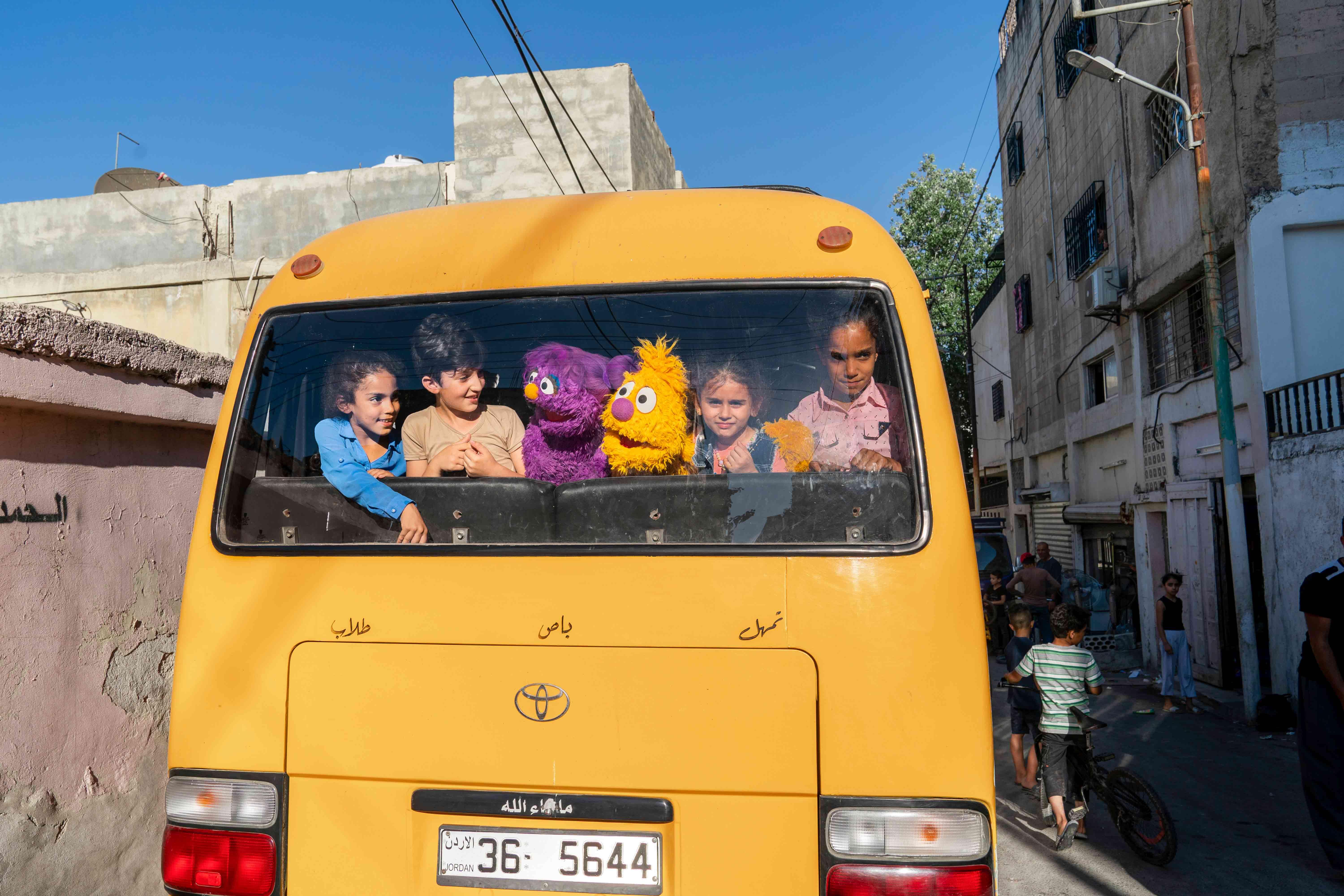 Die neuen Sesamstraße Puppen Jad und Basma nehmen den Bus mit Flüchtlingskinder in Amman 