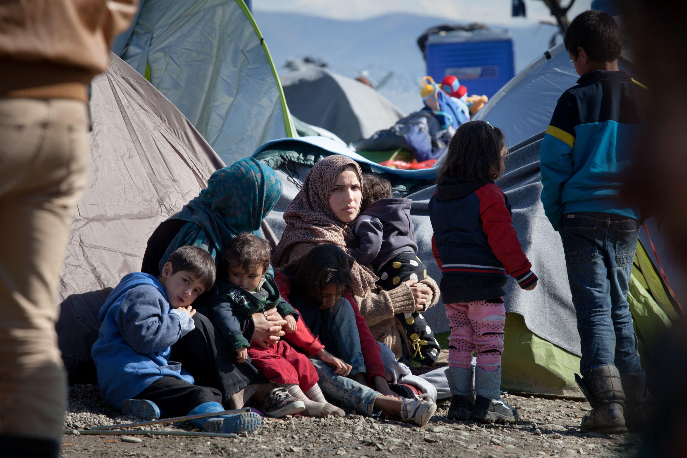 En barnfamilj sitter i ett flyktingläger