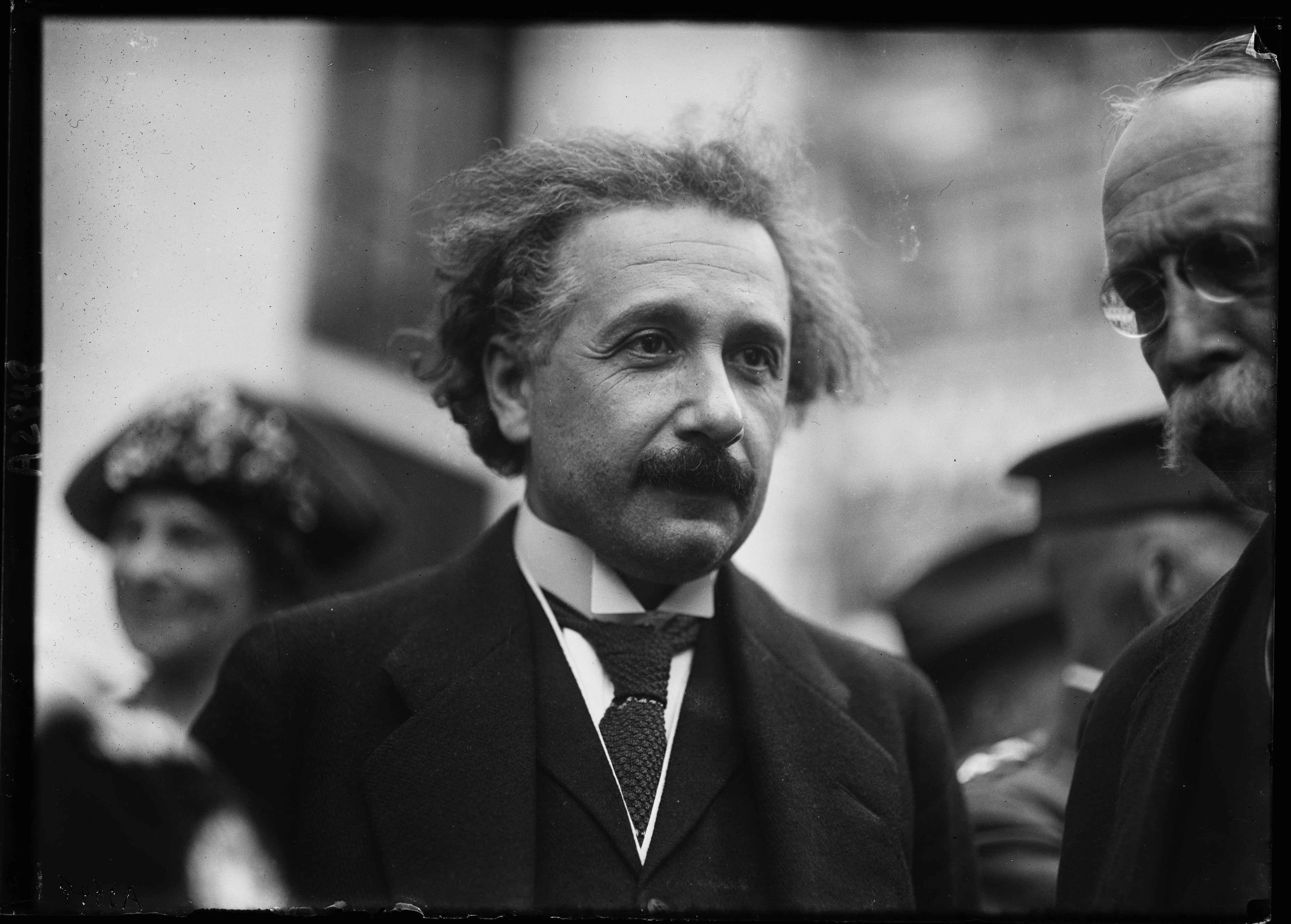 Albert Einstein umgeben von Leuten.