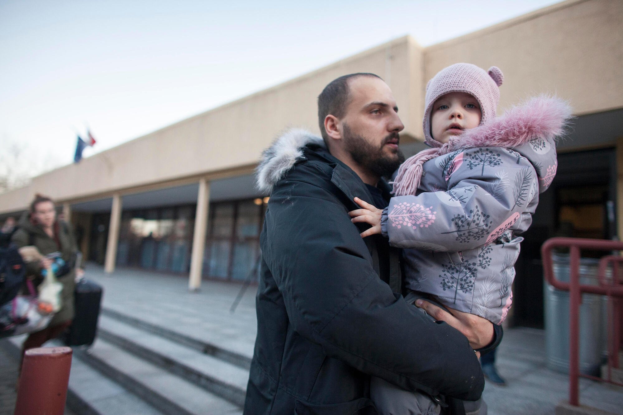 En pappa håller sitt barn i famnen på flykt från Ukraina