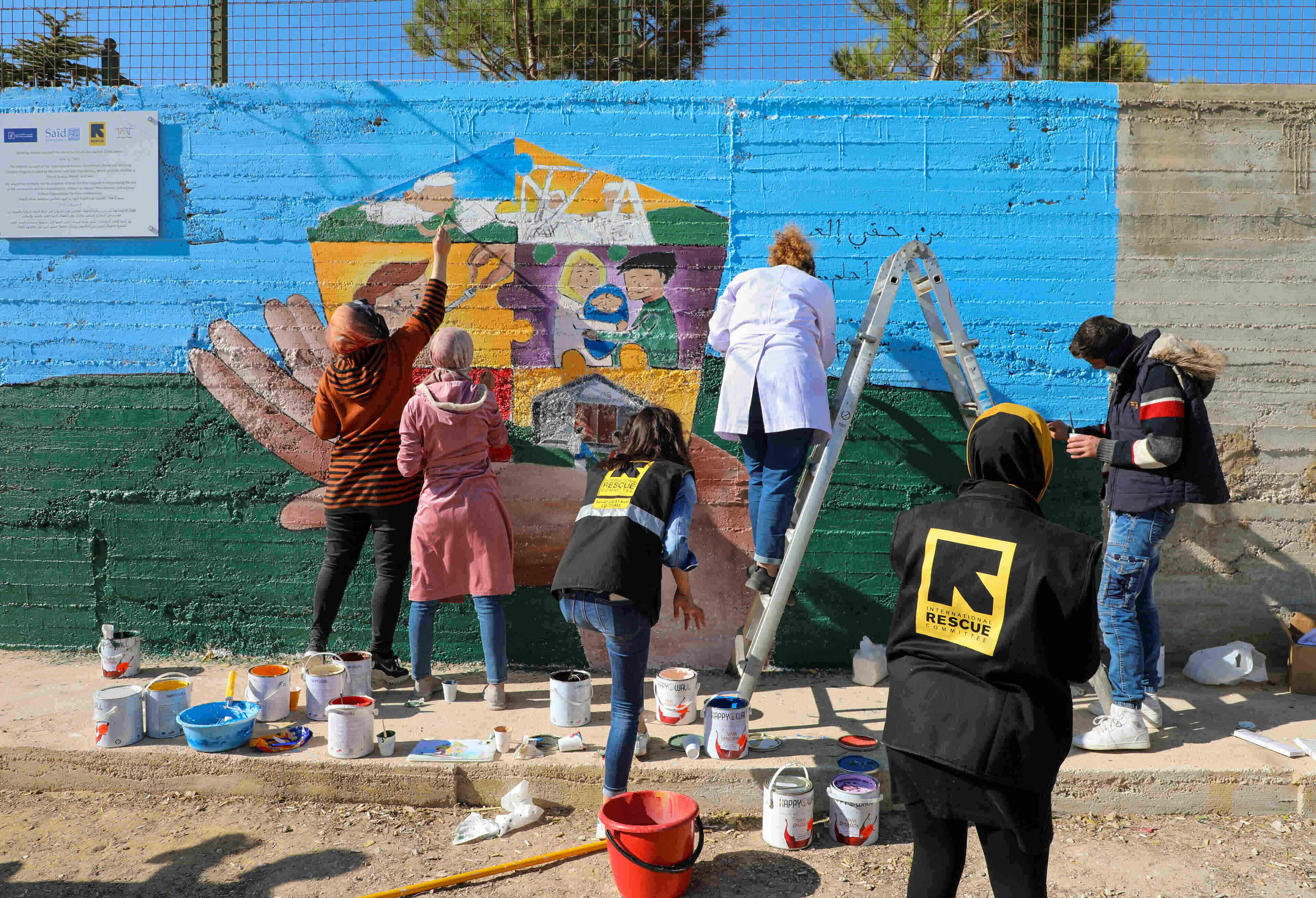 Teenagers taking part in an IRC child protection program in Lebanon paint a mural for World Children's Day 2021 to help raise awareness of children's rights. Photo: IRC
