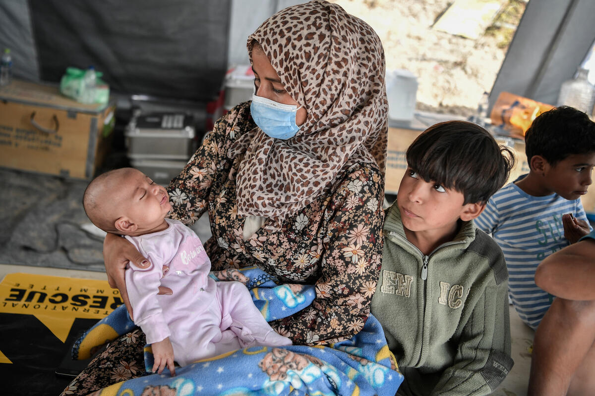 Syrian mother holding her sick baby daughter