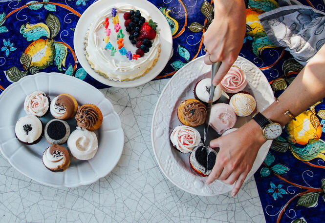 A person cuts up cakes at charity birthday party