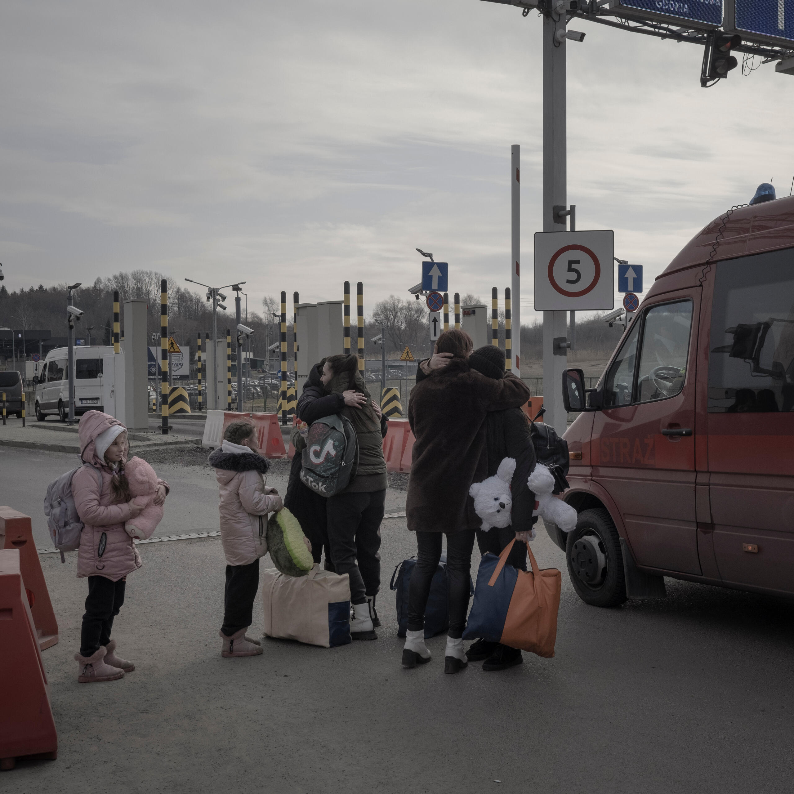 어떤 우크라이나 가족은 밴 옆에서 우크라이나에서 폴란드 국경으로 넘어가며 포옹하고 있습니다.