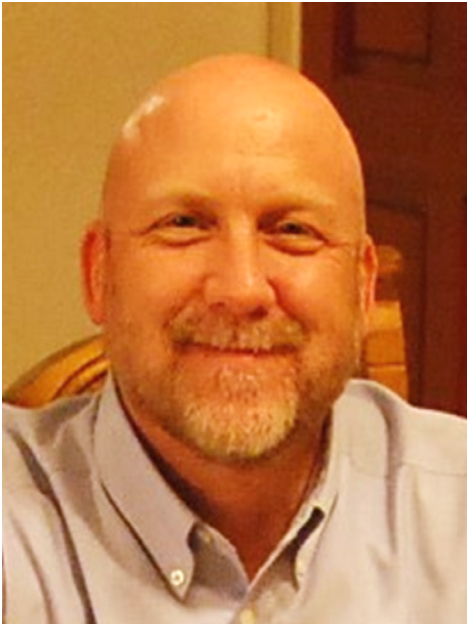Picture of Jeffrey Cornish, Executive Director, smiling at camera in a blue button-up shirt.