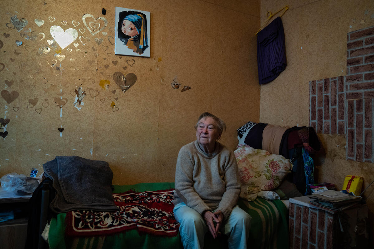 A Ukrainian woman sitting in her studio apartment