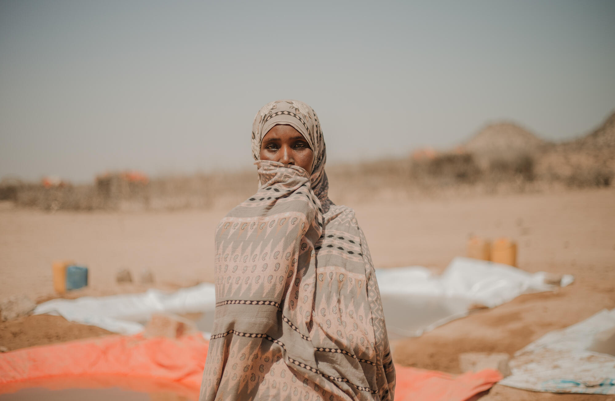 Bilan, 40, stands facing camera at Kambe Kebele water point.