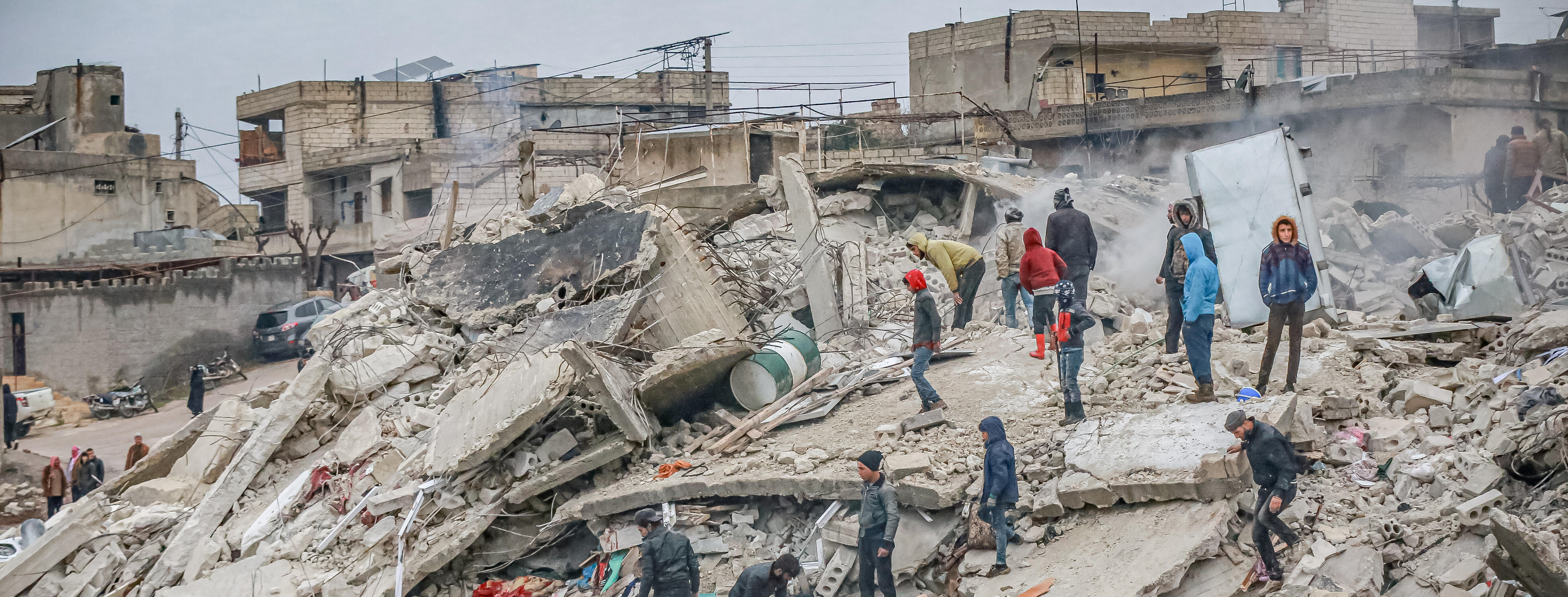 A crowd of medical personnel and civilians conduct search and rescue operations in the remains of destroyed buildings in Syria after the 7.7 earthquake on the morning of February 6, 2023. 