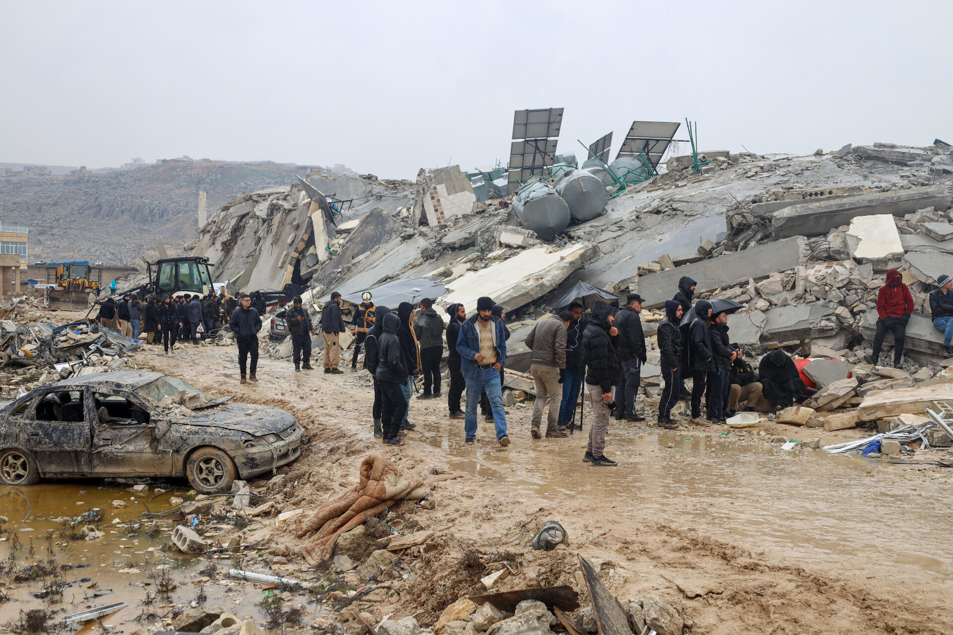 Residents observe a collapsed building.