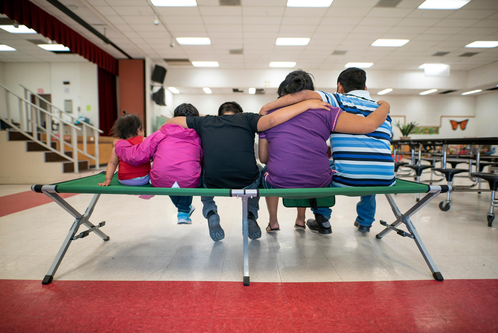 Marta, Julio and their children sit with their backs to the camera.