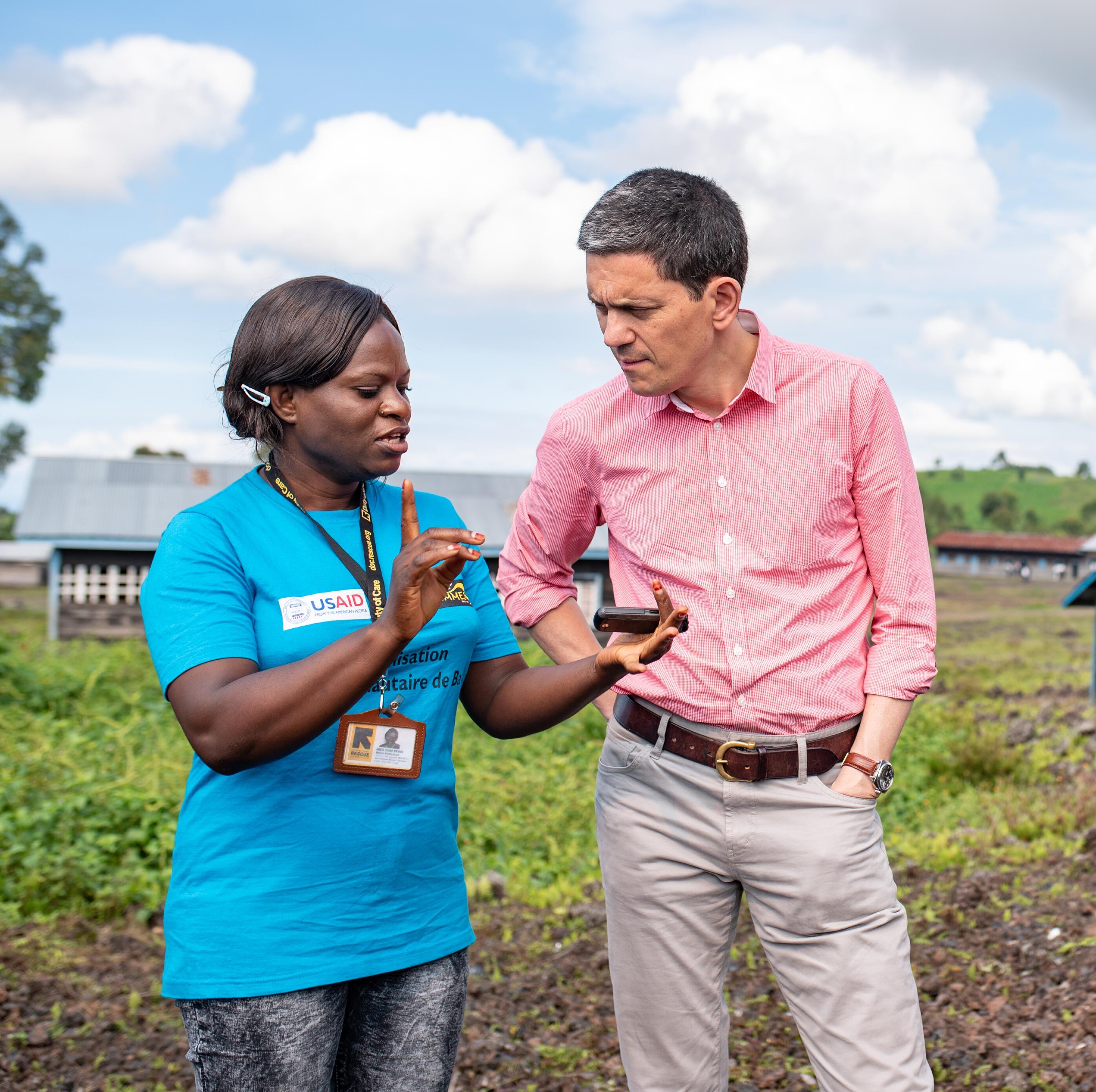 IRC president and CEO David Miliband speaks to an IRC staff member outside a community space where women take part in activities designed to support women and girls in Goma, Democratic Republic of Congo