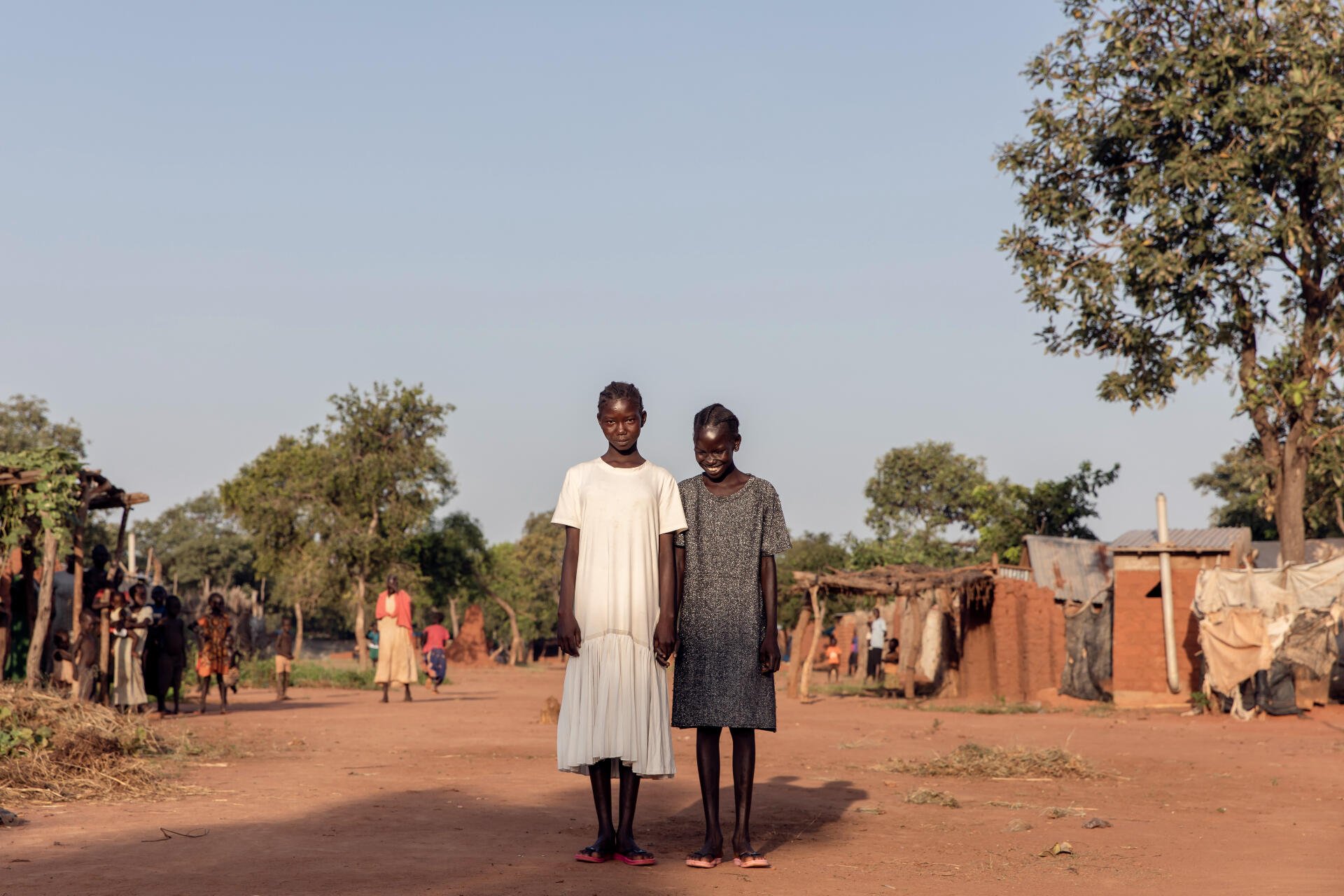 Zwei Mädchen posieren für ein Foto in Südsudan. Sie lächeln beide.