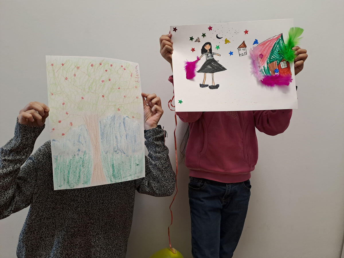 Karima's children holding drawings