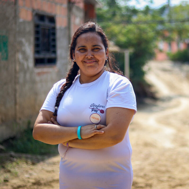Omaira, a Women’s Protection and Empowerment Advocate standing proudly outside of a building in Colombia.