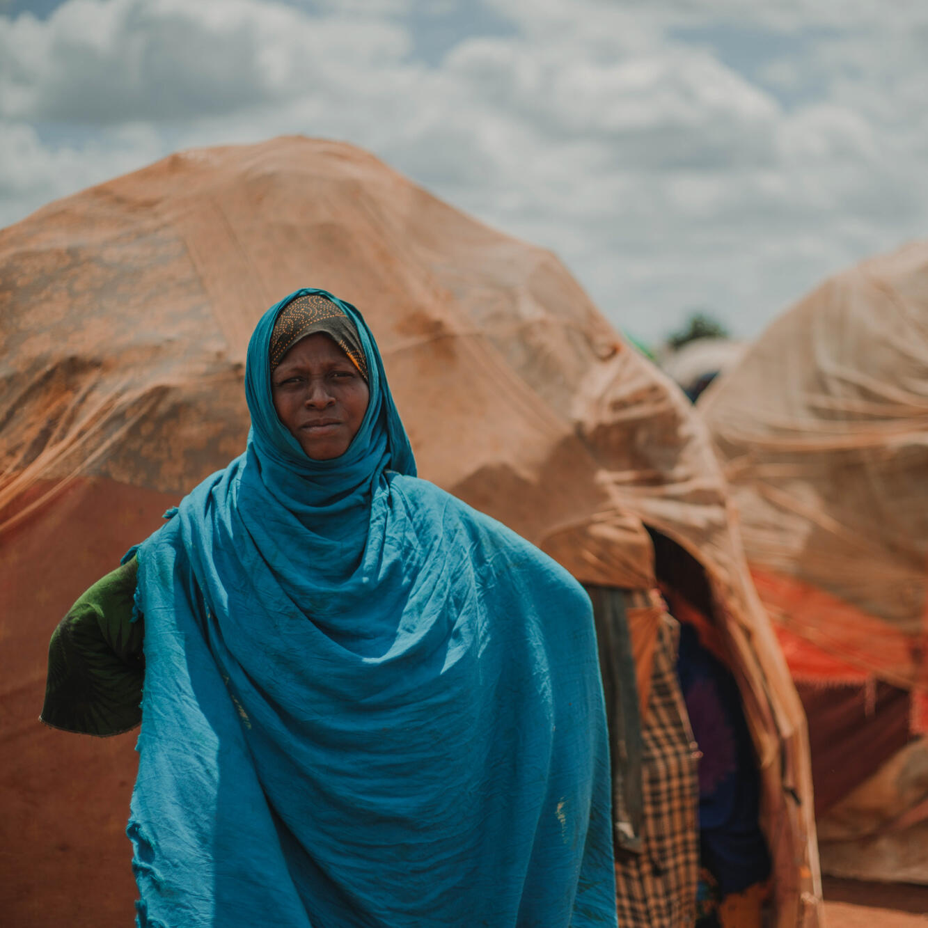 Bistra Abdullahi stands in front of her home in Tortorow camp in Somalia.