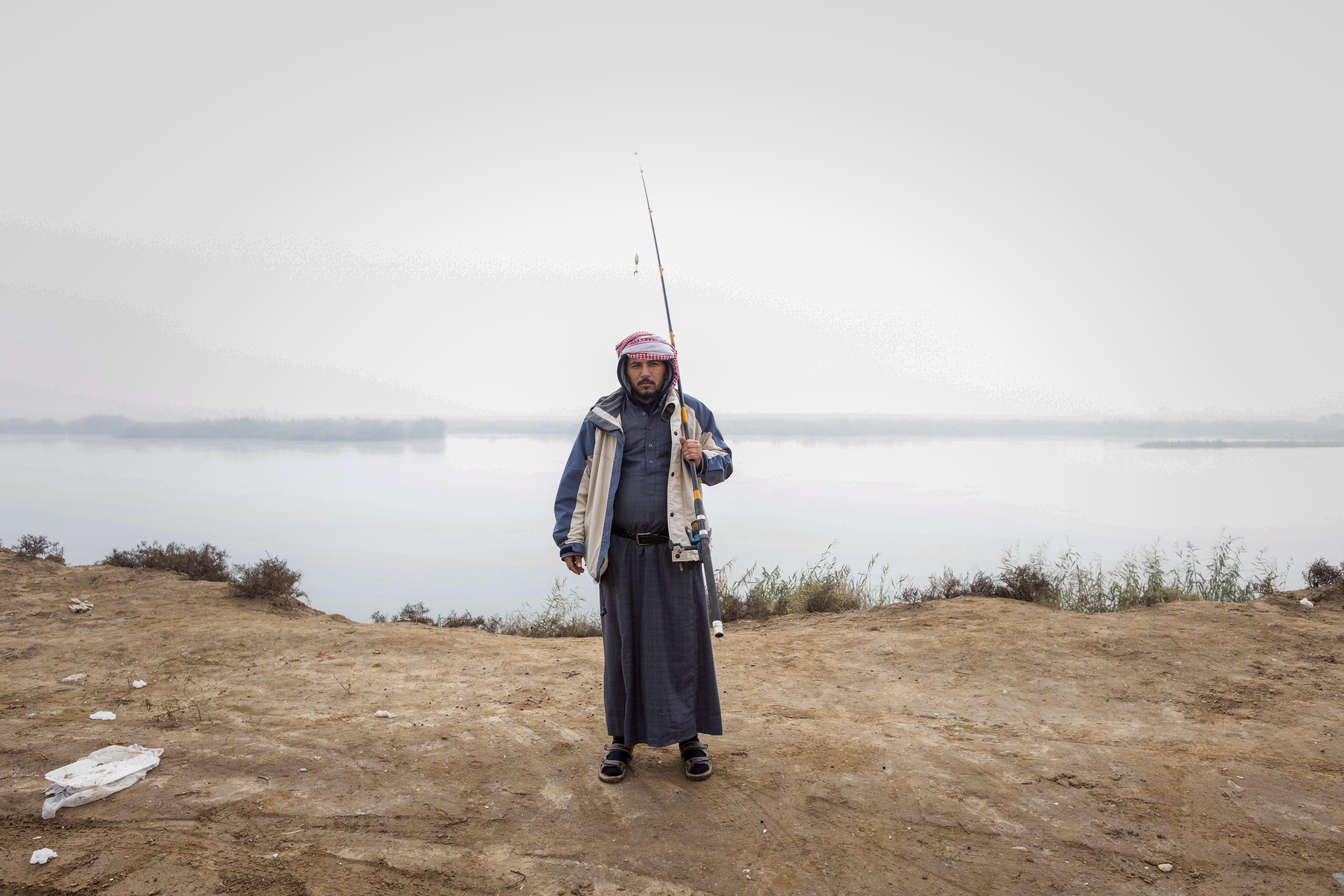 Salem*, a fisherman who recently recovered from cholera, stands by the Euphrates River. He had received full health care from the International Rescue Committee (IRC), besides awareness and education sessions for him and his family.