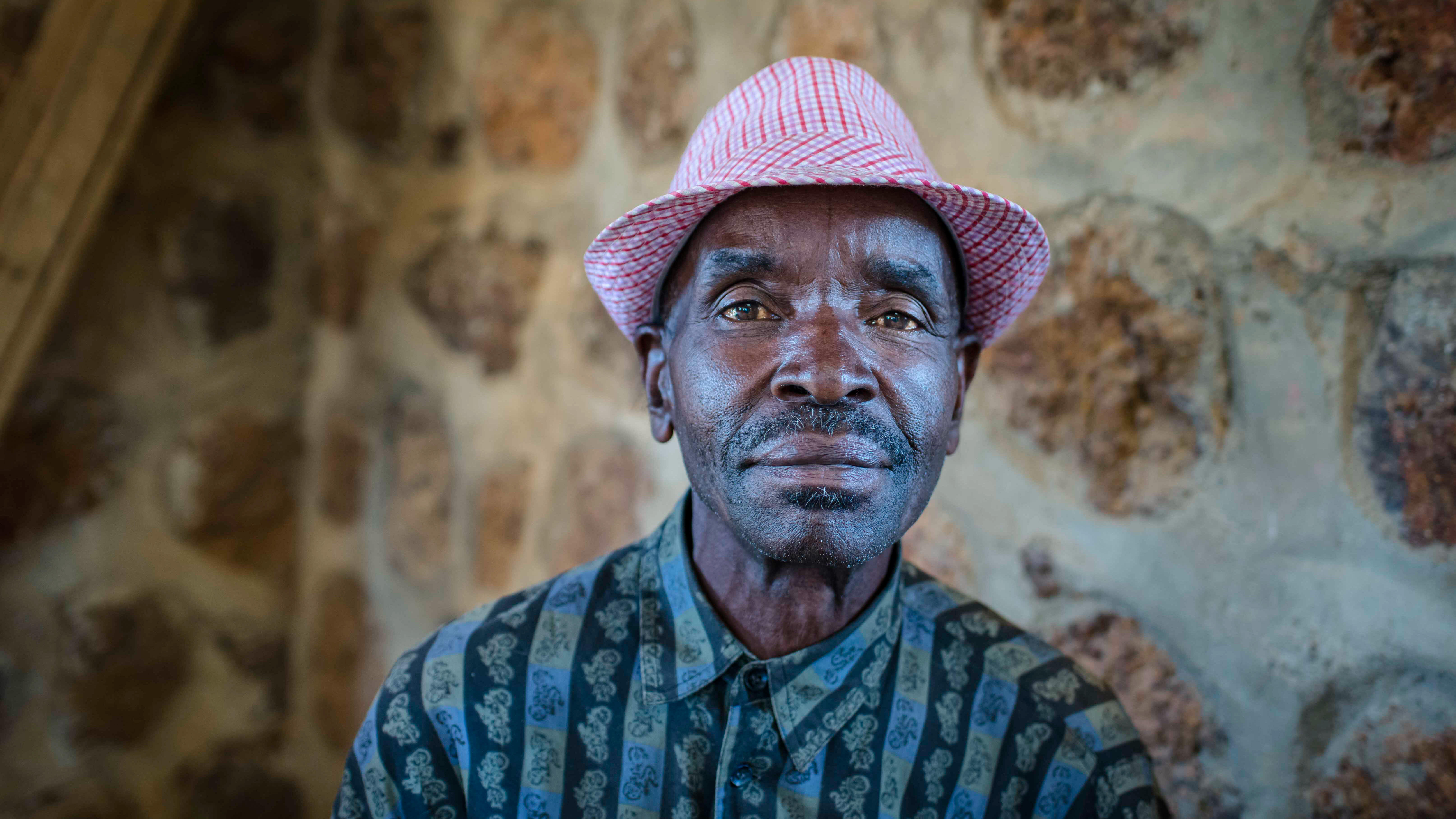 A portrait of a woman who poses for a photo in a classroom in Central African Republic.