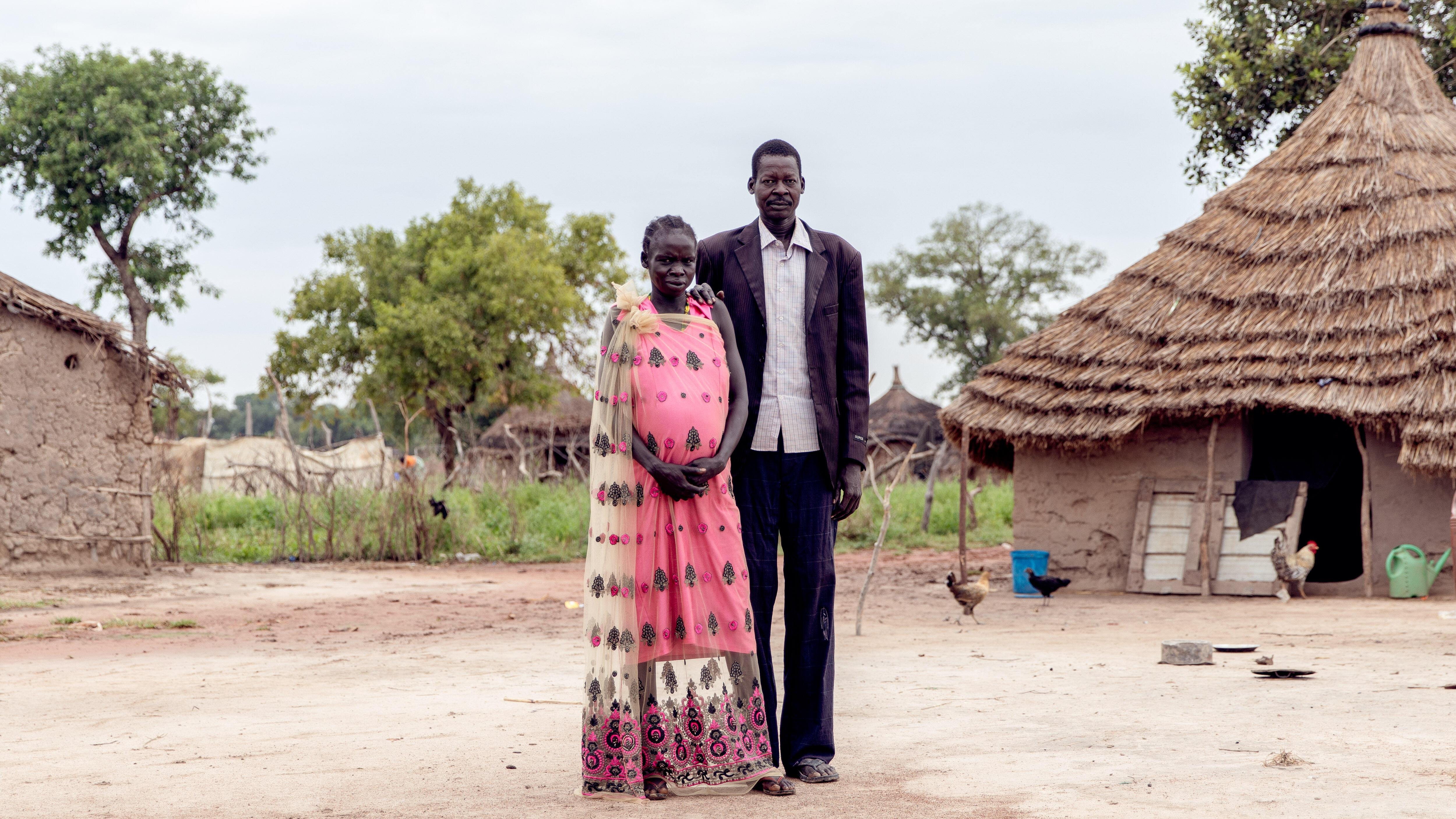 Ein Mann und eine Frau posieren für ein Foto vor ihrem Haus im Südsudan.