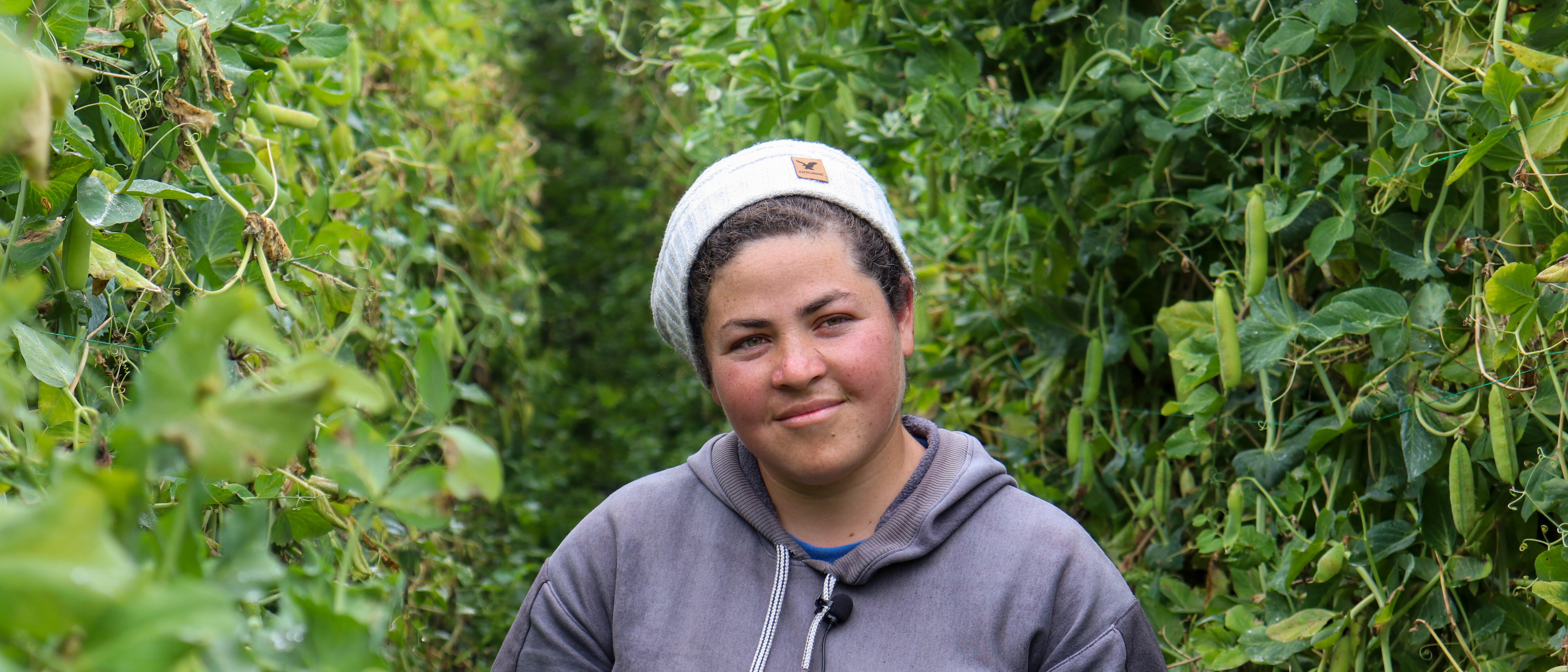 A woman poses for a portrait in a field.