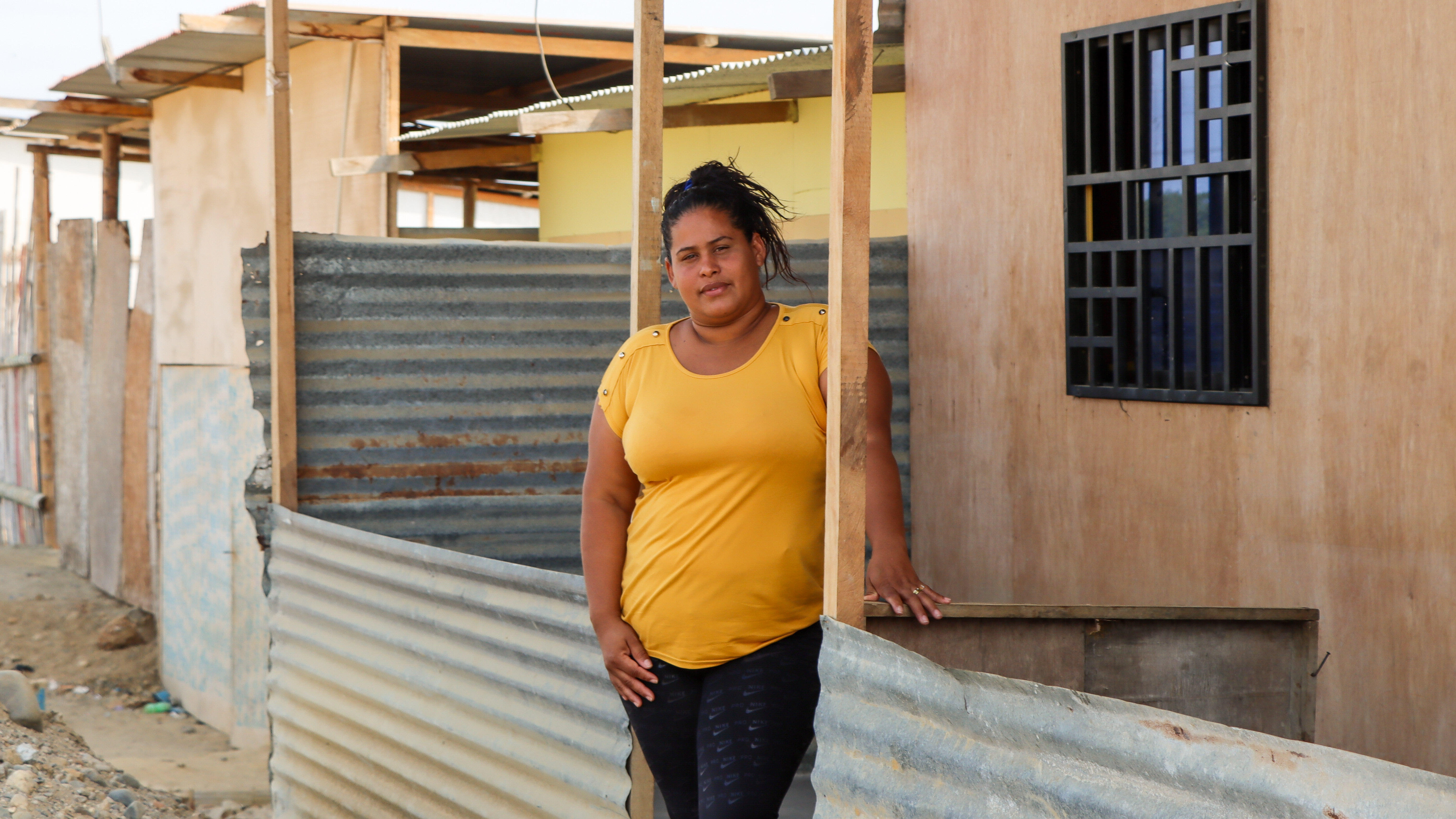 Scarlett, a client of the IRC, poses for a photo outside of a house.