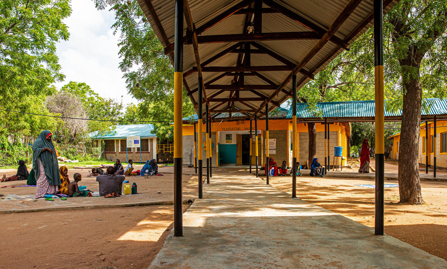 Patients sit with their families outside the pediatrics ward of the Hagadera Refugee Camp Hospital.