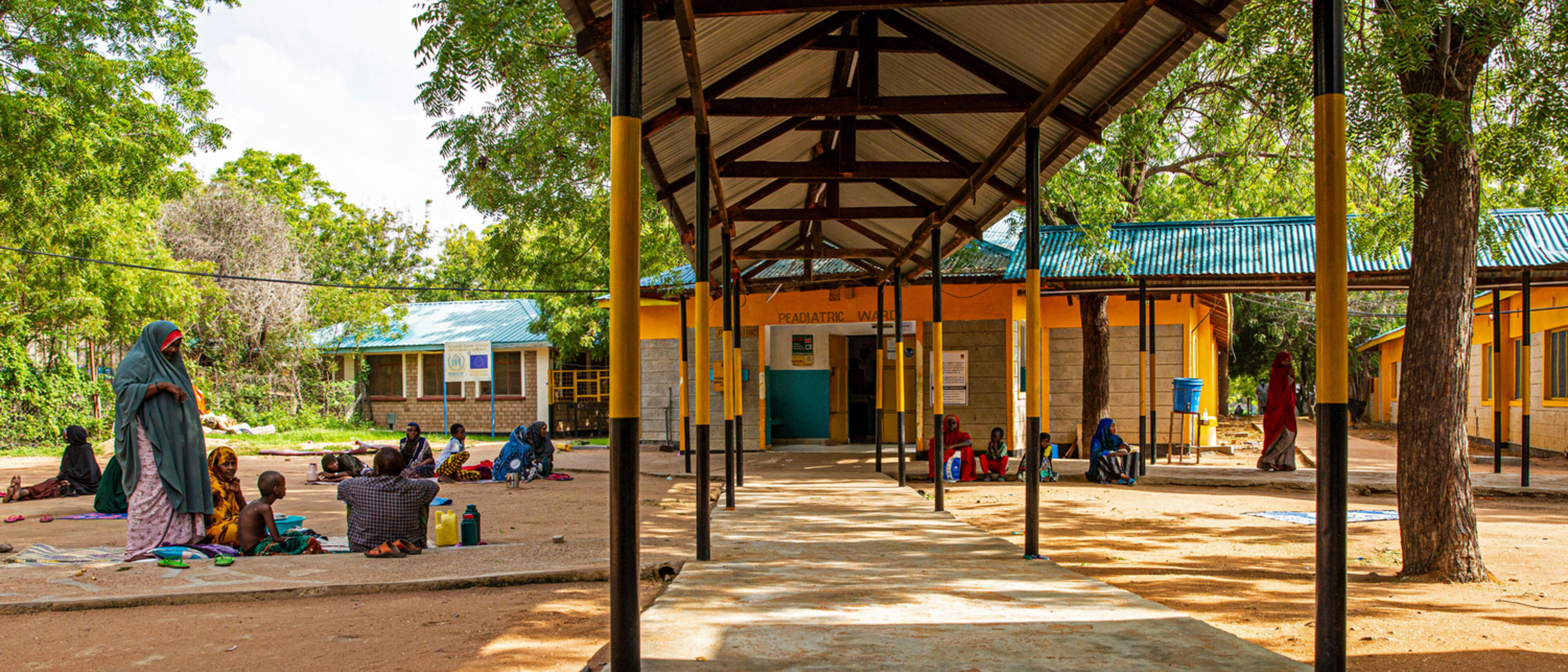 Outside the female ward at the IRC’s Hagadera Refugee Camp Hospital, Kenya (part of the Dadaab complex). Families of patients walk out during visiting hours.