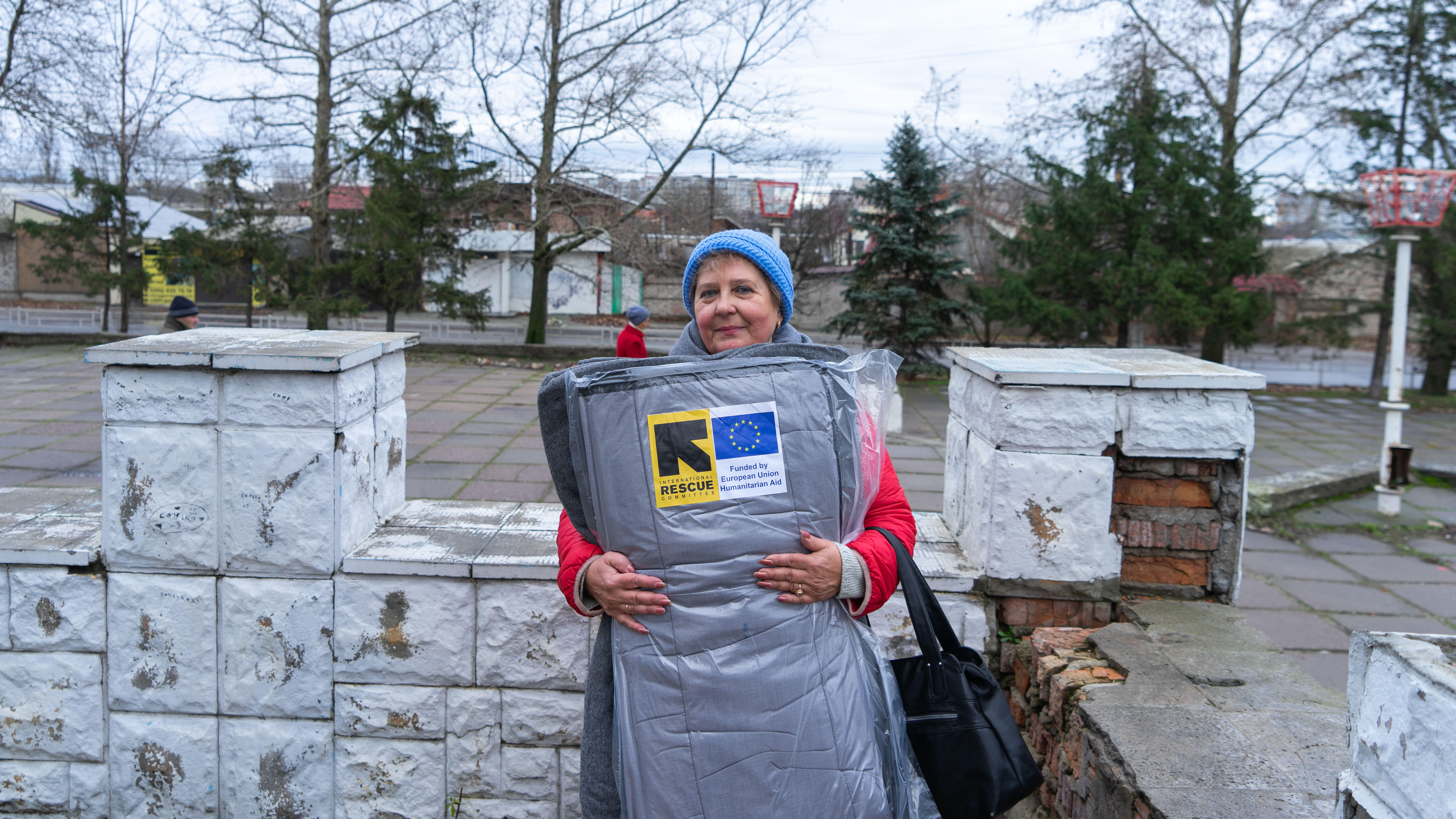 A woman in Ukraine receives a winter kit from the IRC