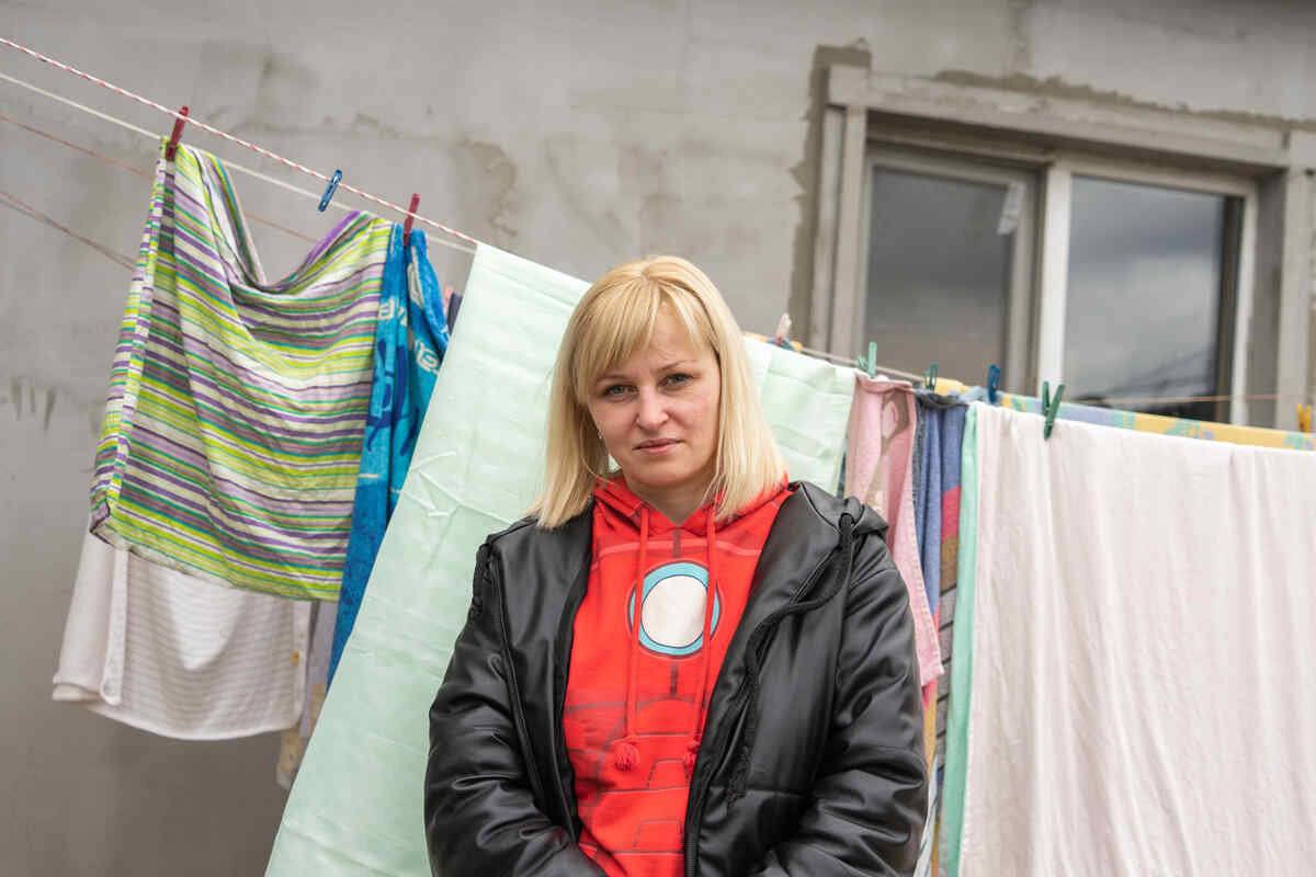 Tetiana standing in front of a clothes line full of laundry
