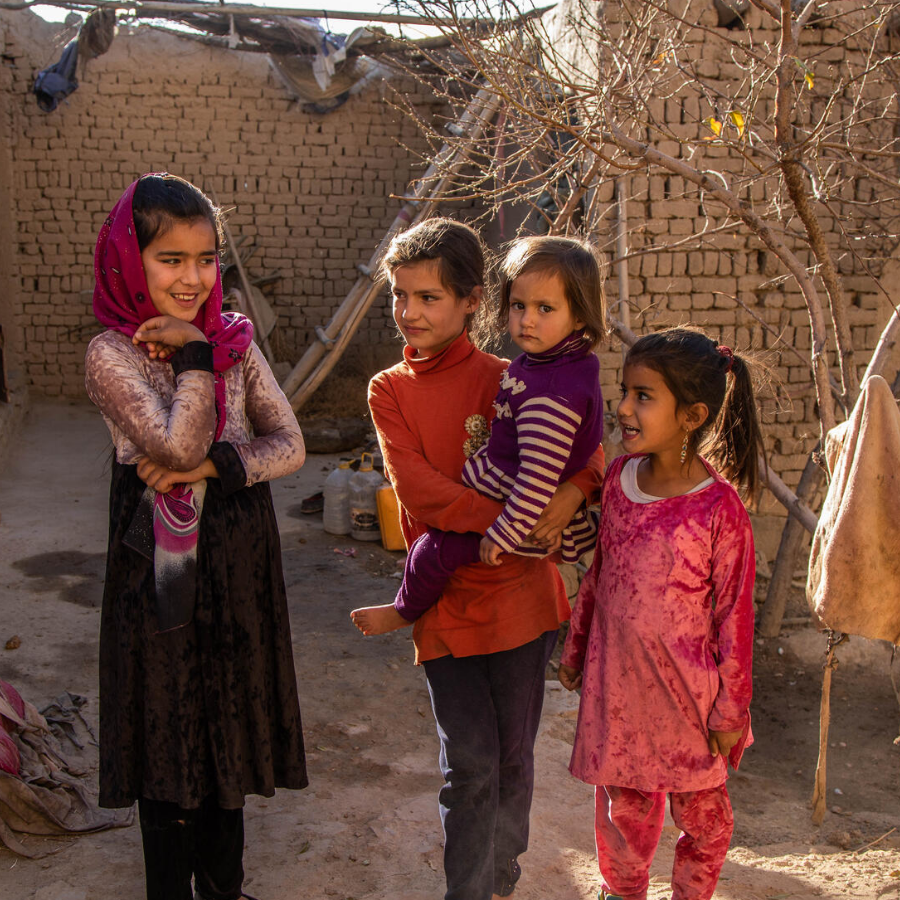 Siblings standing together outside.