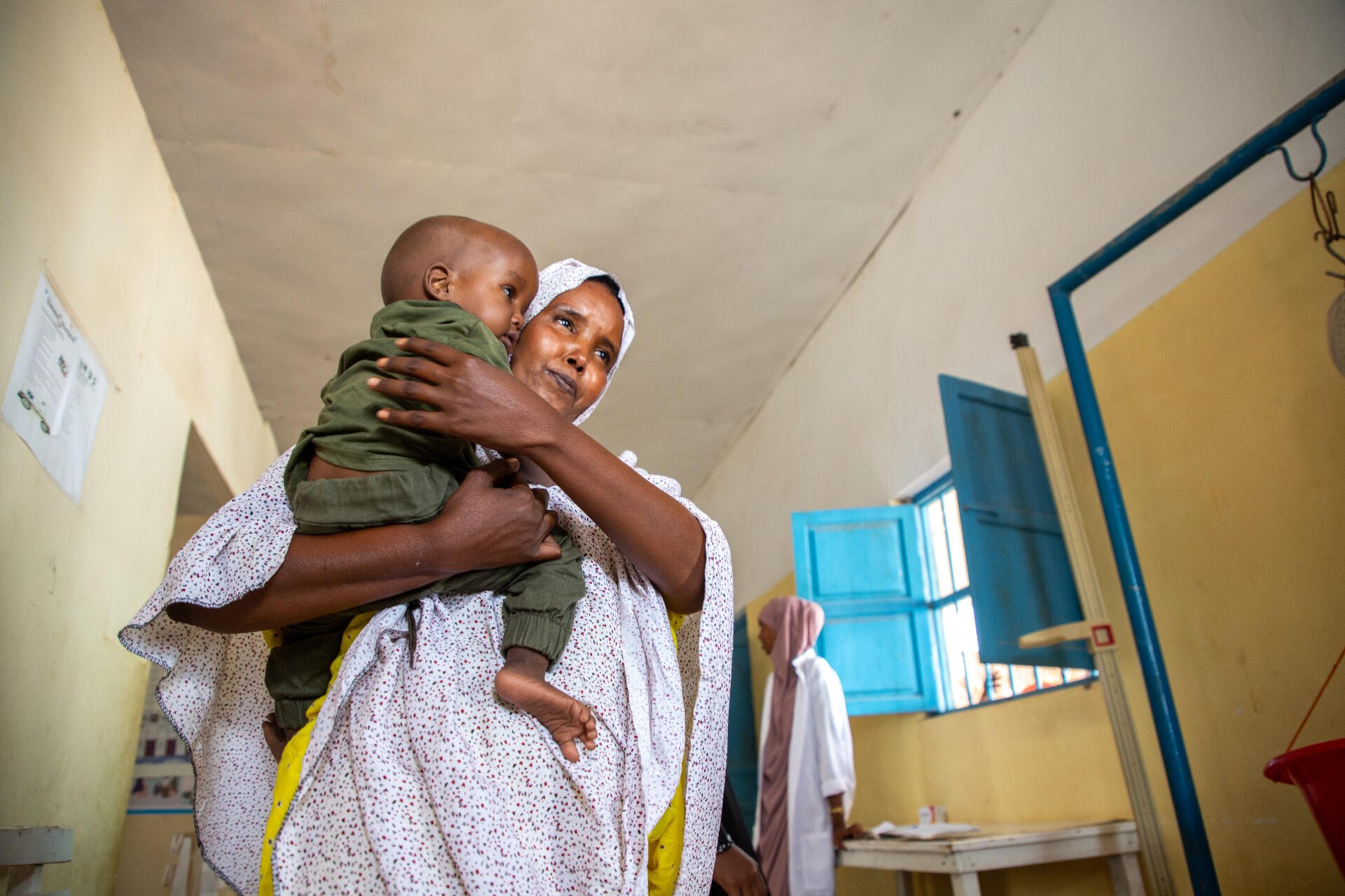 A mother holds her child close as the two walk through a malnutrition treatment ward in the Hanano Hospital in Somalia.