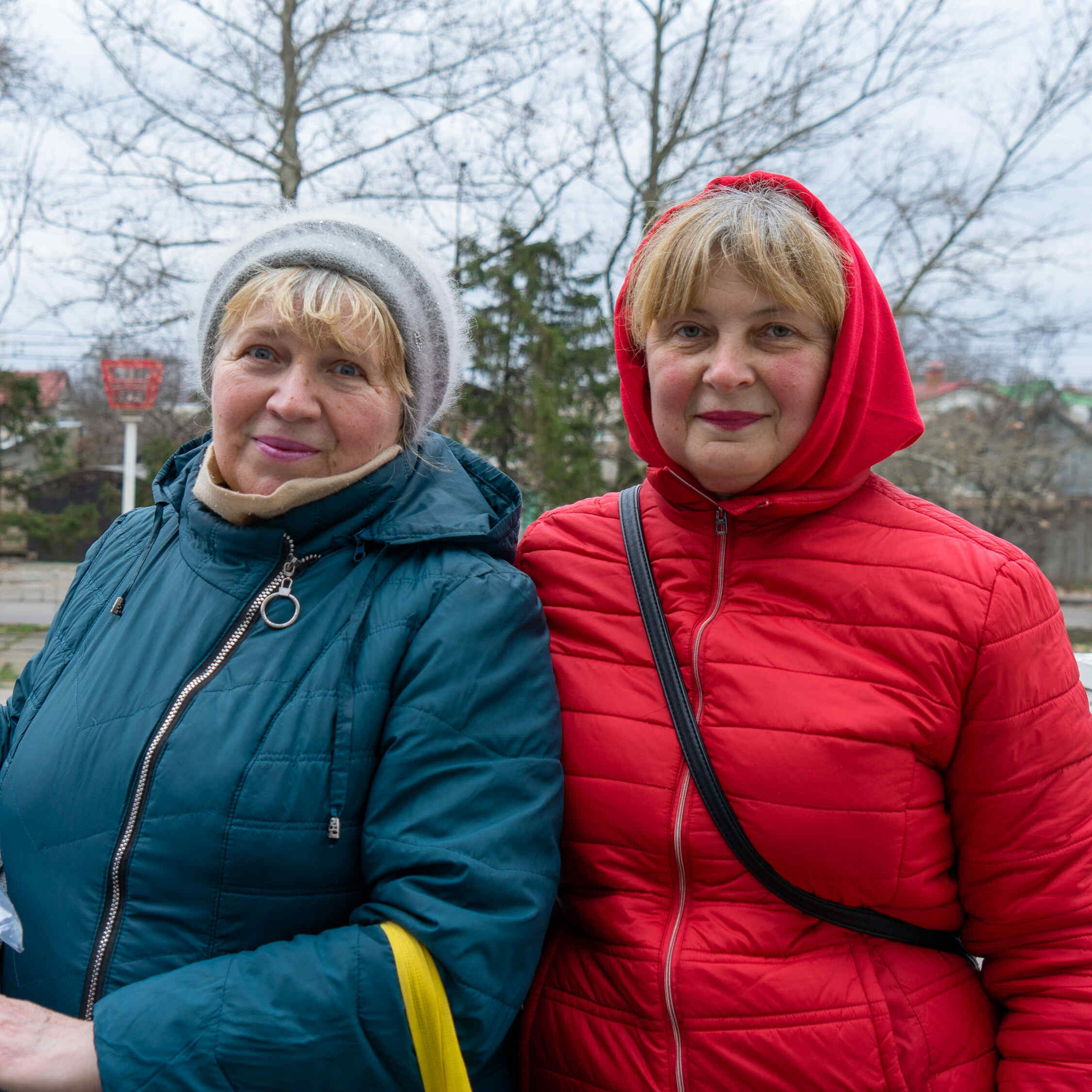 Two women in Kherson, Ukraine are showing their winter kits they received from the IRC.
