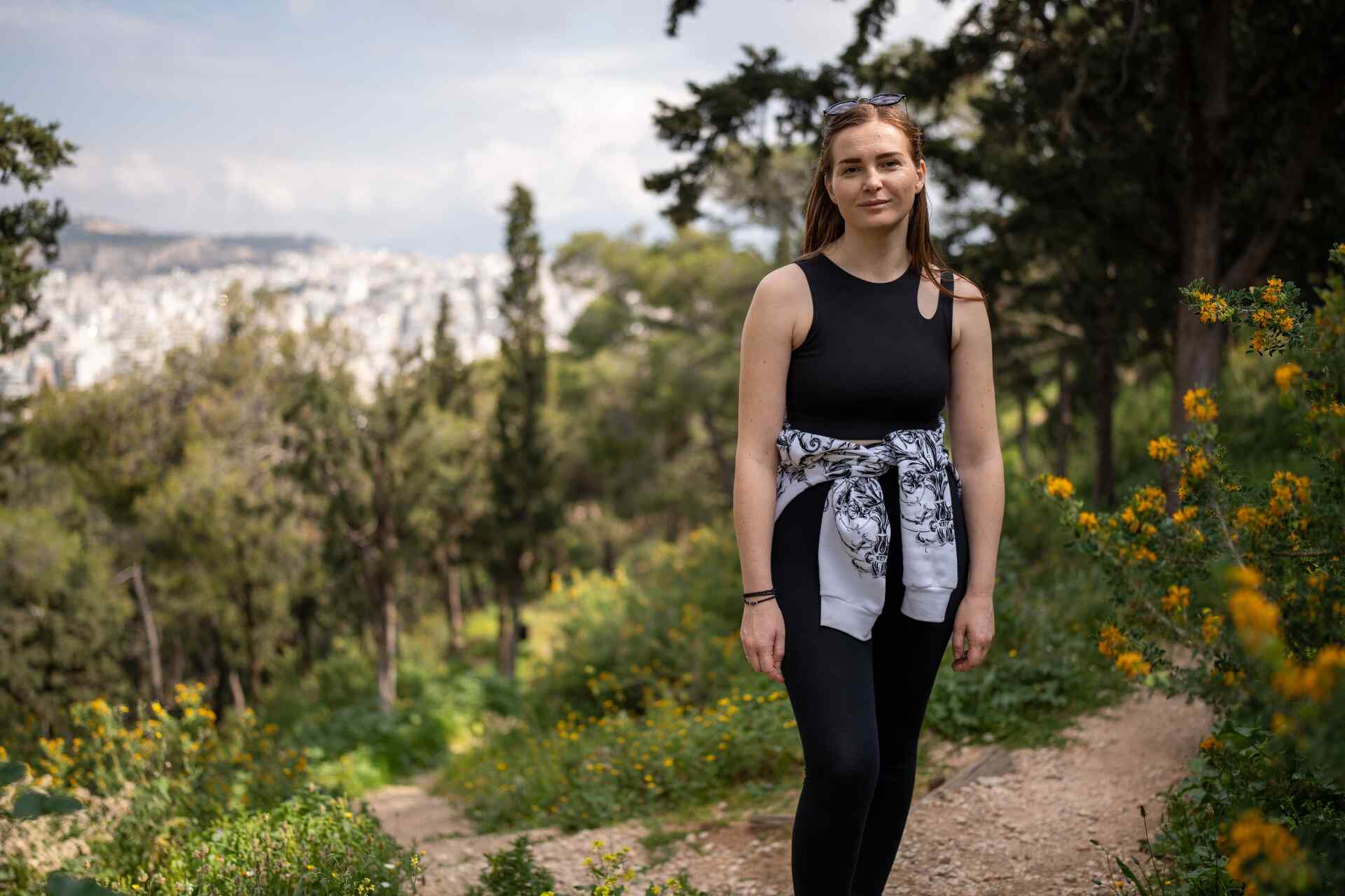 Khrystyna stands tall and poses for a picture in a forest.