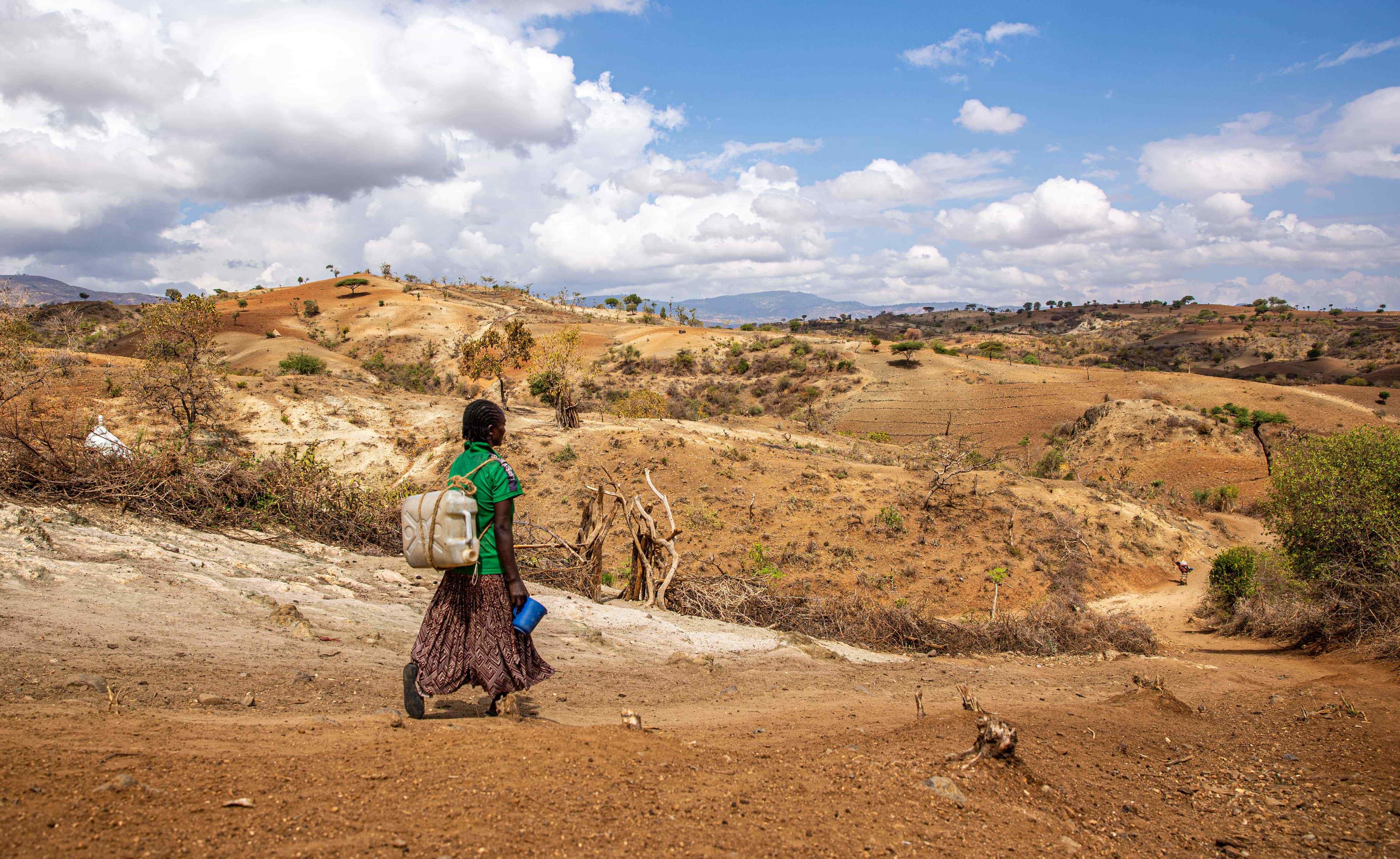 Makito walking 3 kilometers to fetch water for her family. While conflict forced Makito and her family to flee for their lives empty-handed, it’s climate change that’s kept her from being able to rebuild her life without access to the water and resources she needs to start farming again. 