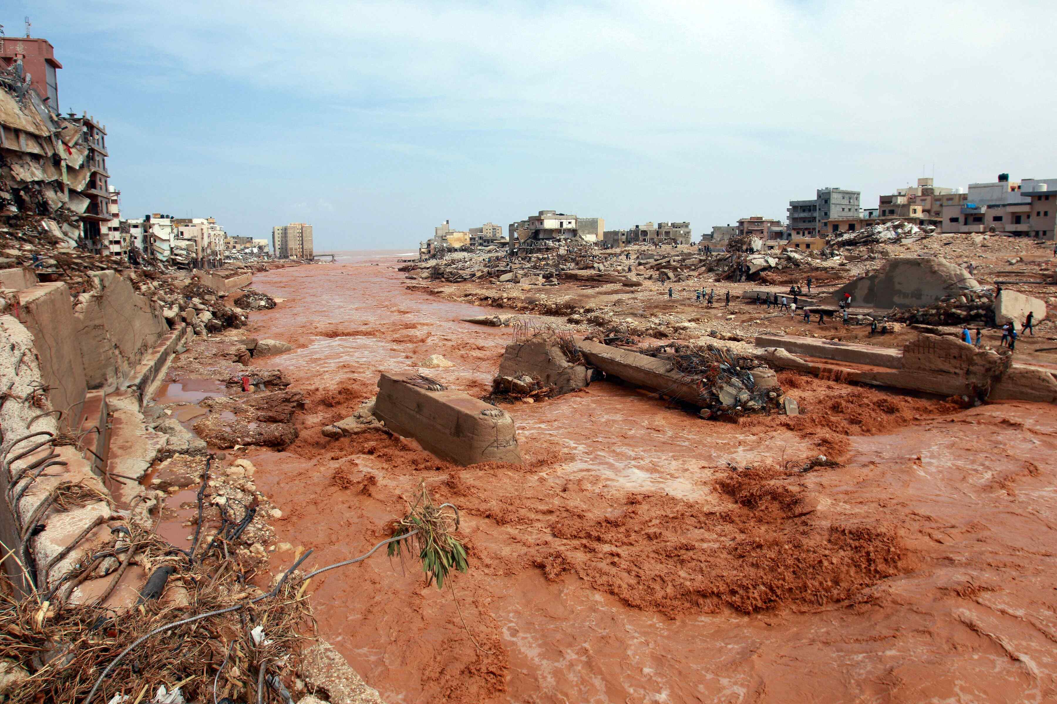 A large portion of the city of Derna, Libya has been swept away by floodwaters. Residents inspect the damage.