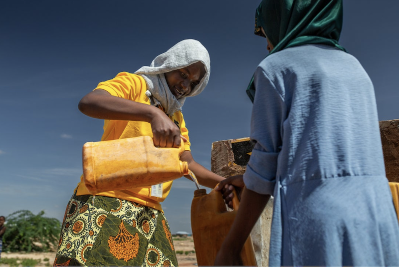 An IRC worker fills a jug with water