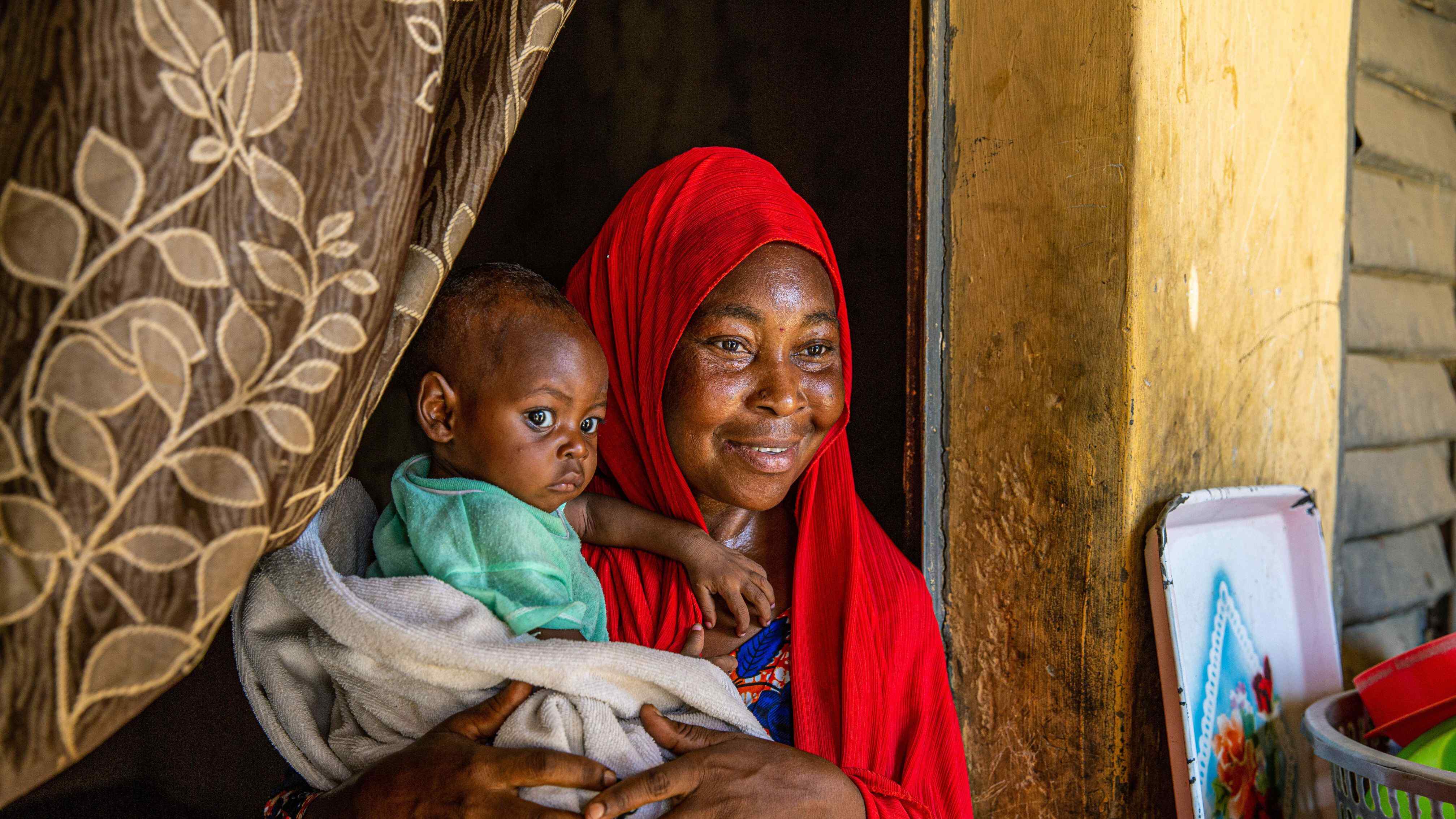 A mother holds her child while posing for a photo.