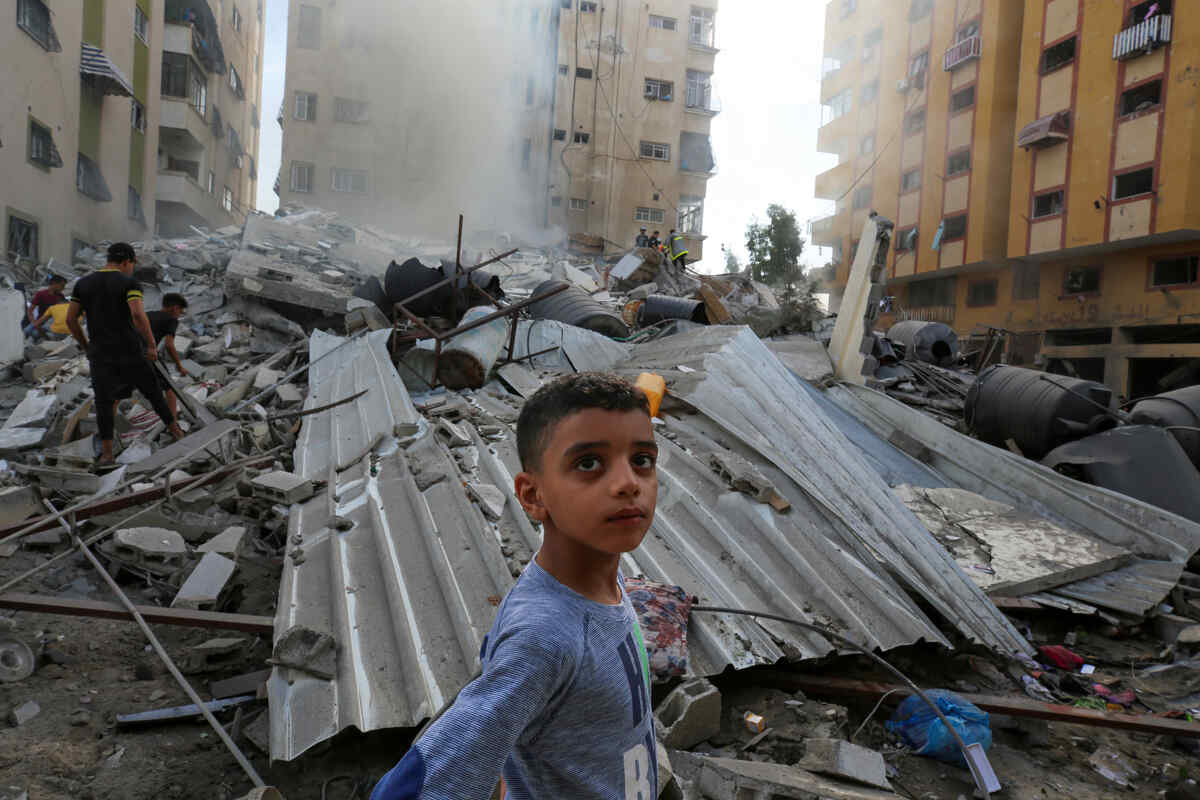 People assess the destruction cause by Israeli air strikes in Gaza City on October 7, 2023.