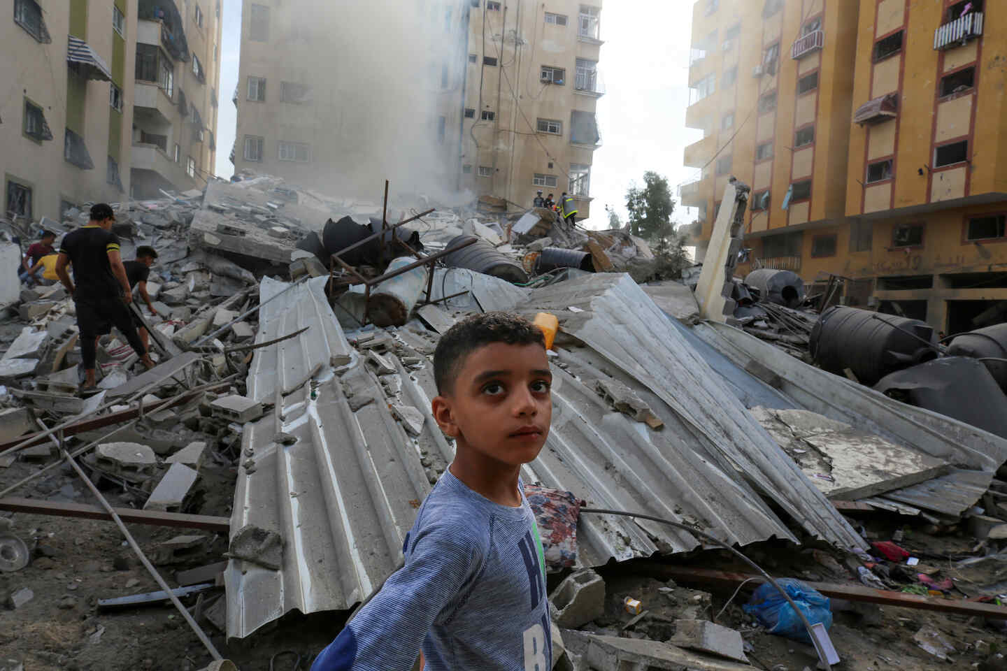폐허가된 가자 지구에서 한 소년이 카메라를 바라보고 있습니다. 