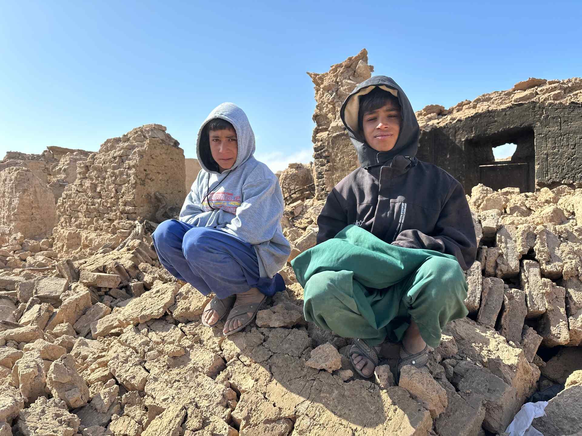 Two boys sit atop a pile of rubble from a building that was destroyed by an earthquake that struck near Herat, Afghanistan.