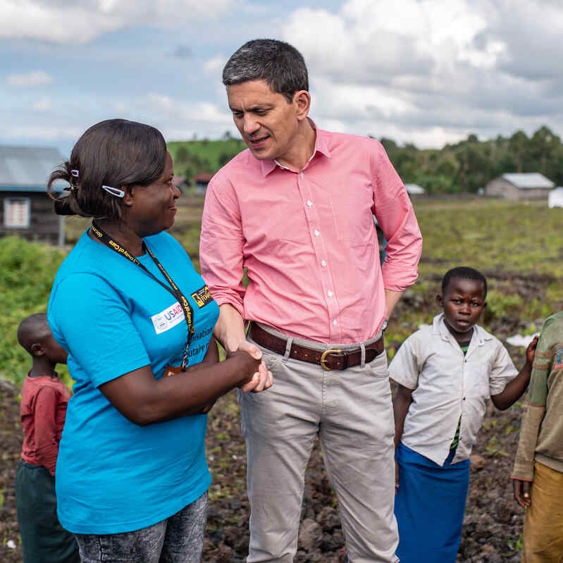 IRC’s CEO and President David Miliband speaks to an IRC staff member outside a community space where women take part in activities designed to support women and girls in Goma, DRC.
