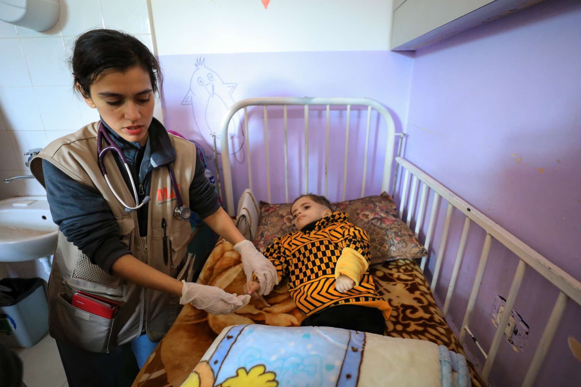 Dr. Jilani tends to a young child at Al Asqa hospital in Gaza.