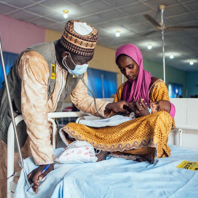 Dr. Mohammed Isa Goni treats Adama Wudaa's child for malnutrition at an IRC stabilization center in Borno, Nigeria.